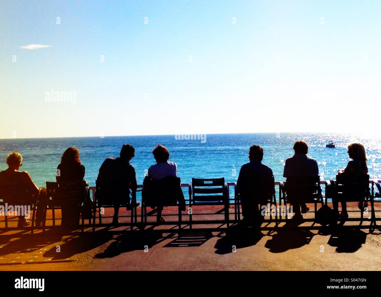 Seniors watching the sunset by the sea - Smartphone Captured Stock Image