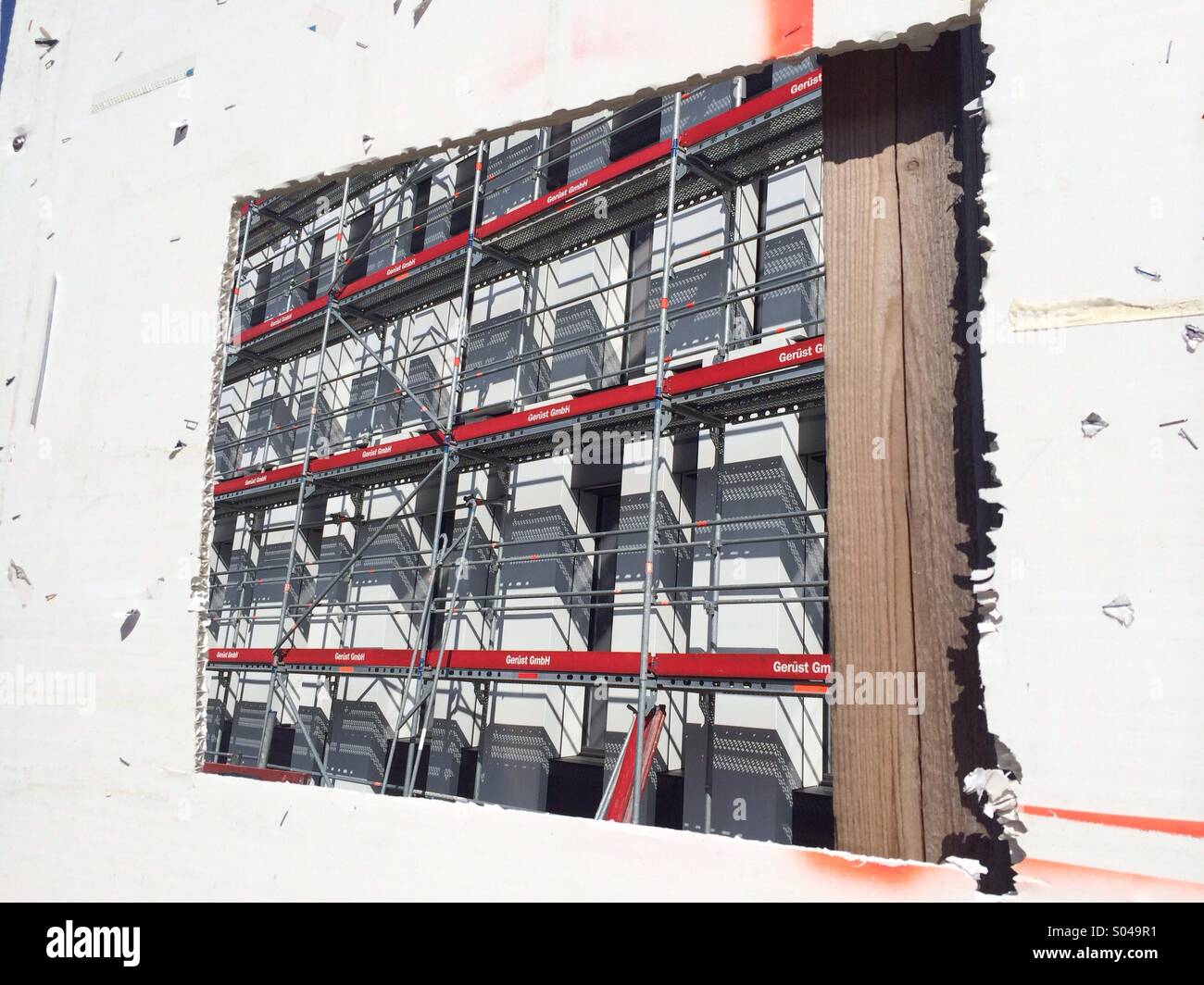New building under construction, viewed through improvised window in a plasterboard wall - Smartphone Captured Stock Image