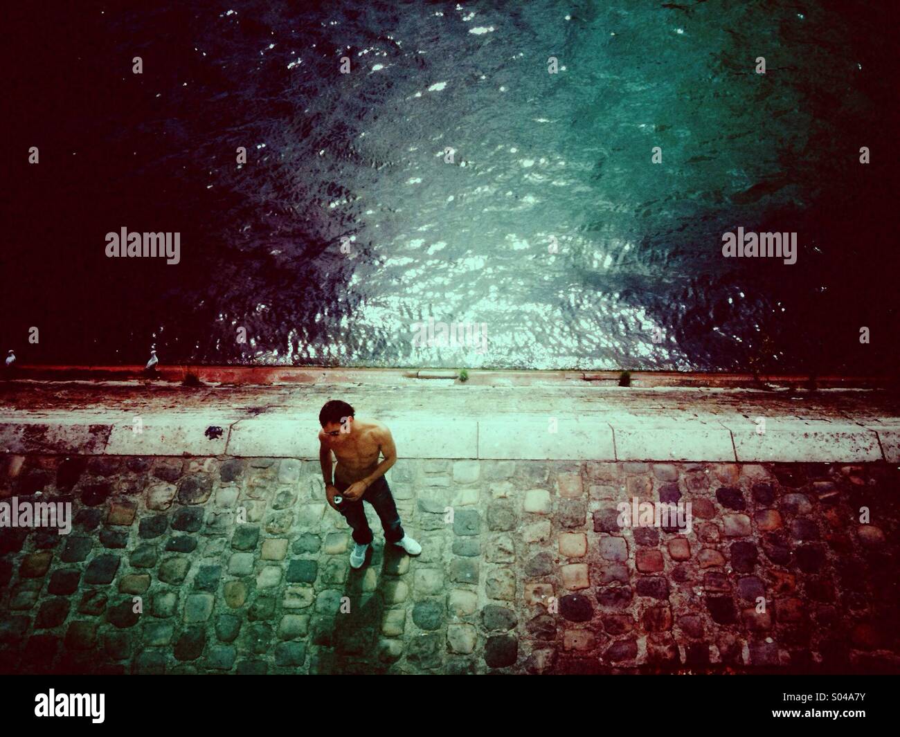 Lonely man standing at the edge of the Seine River - Smartphone Captured Stock Image