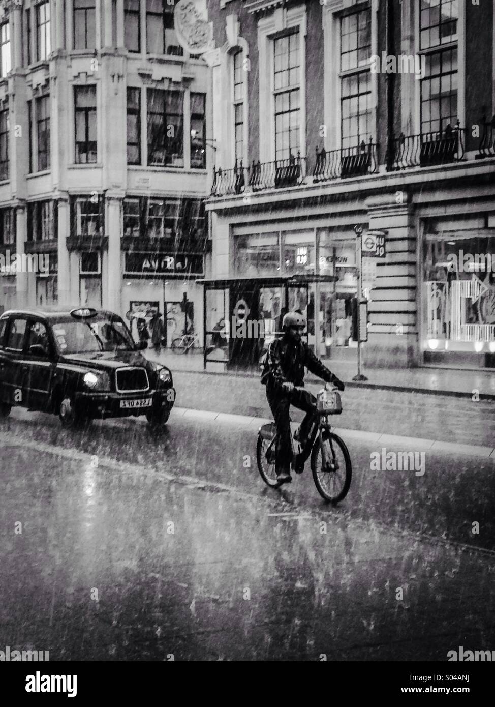 Cyclist riding in the Rain on Oxford Street - Smartphone Captured Stock Image