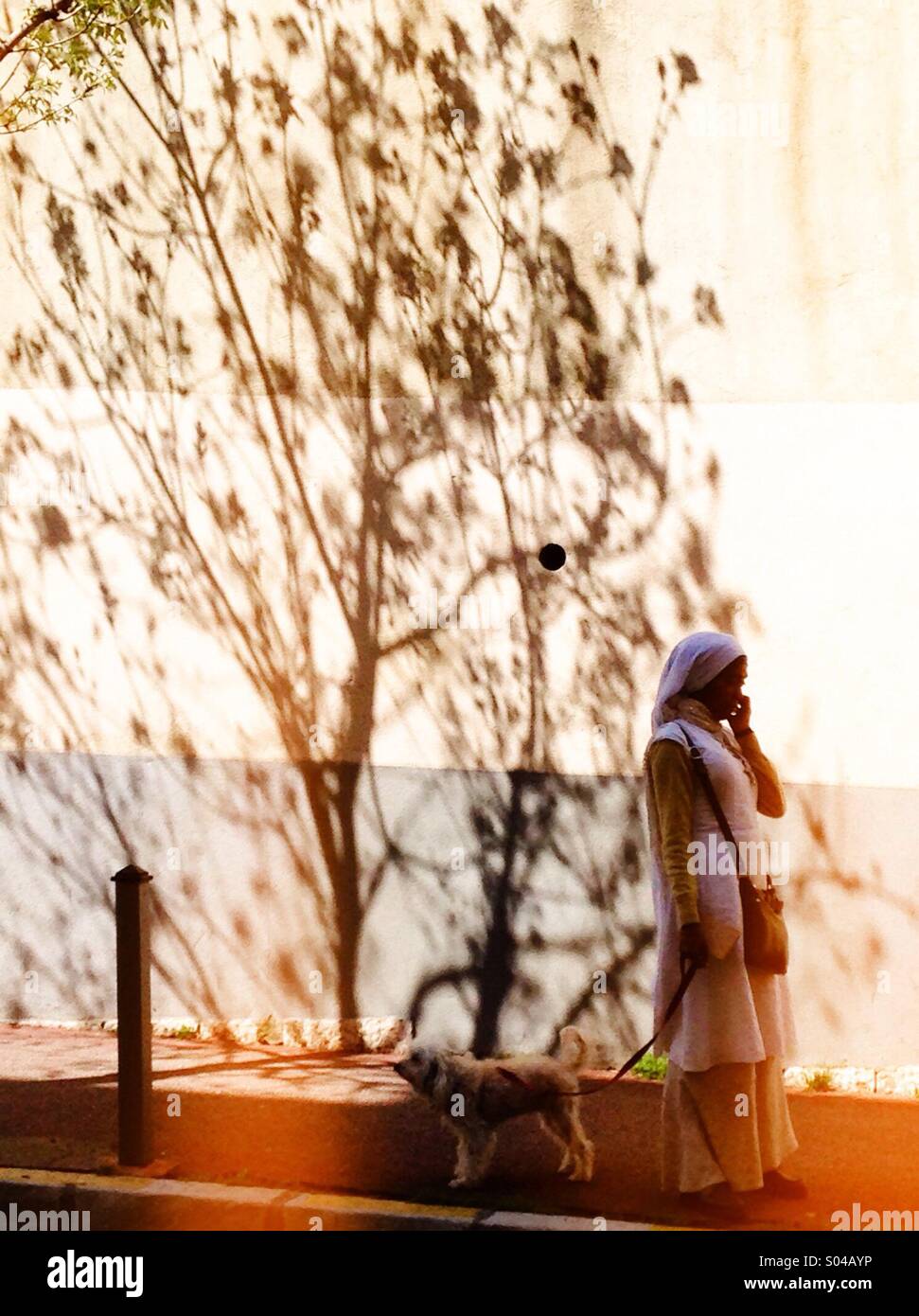 Robed woman walking her dog - Smartphone Captured Stock Image