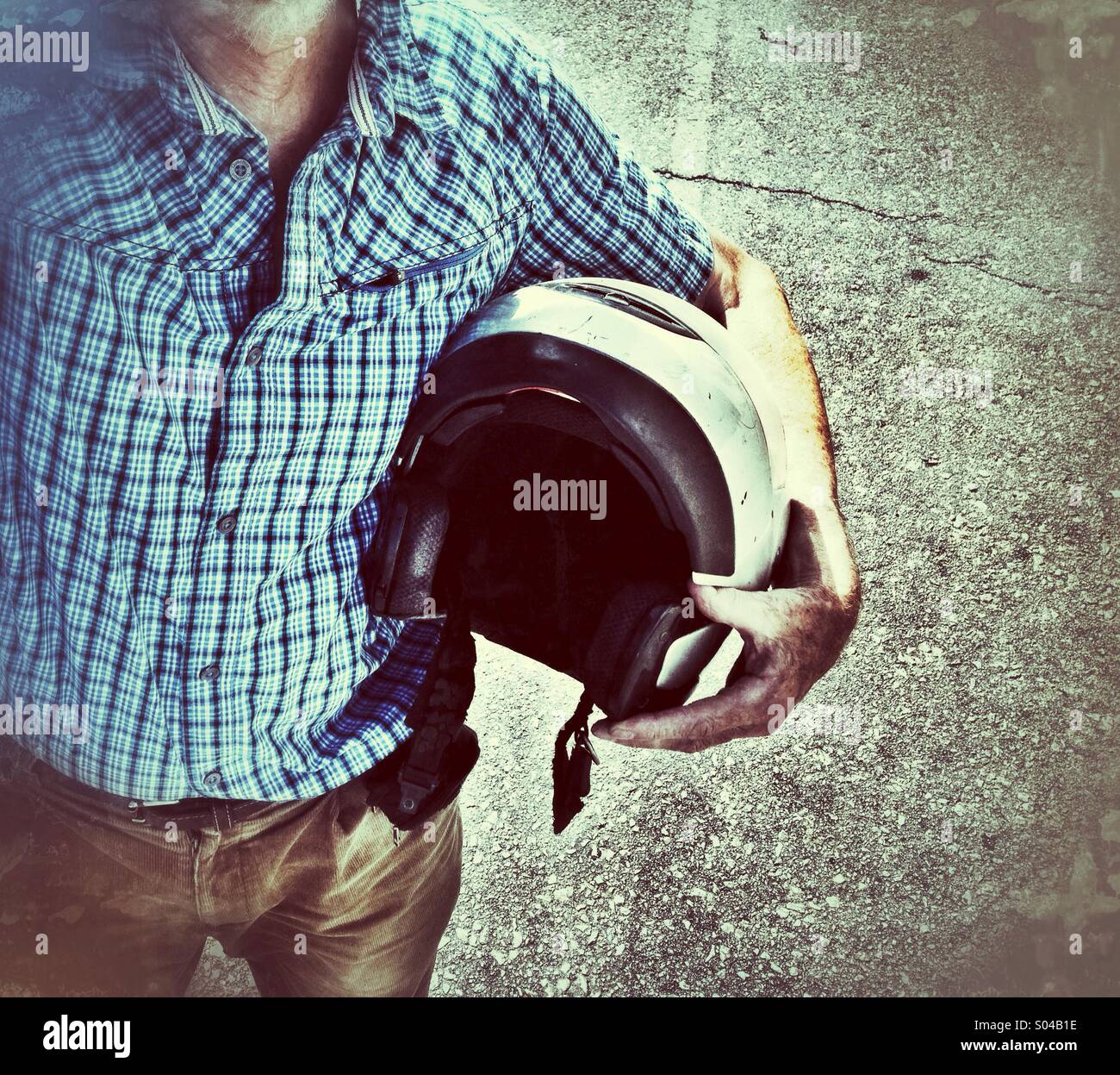 Man carrying motorcycle helmet under arm Stock Photo Alamy