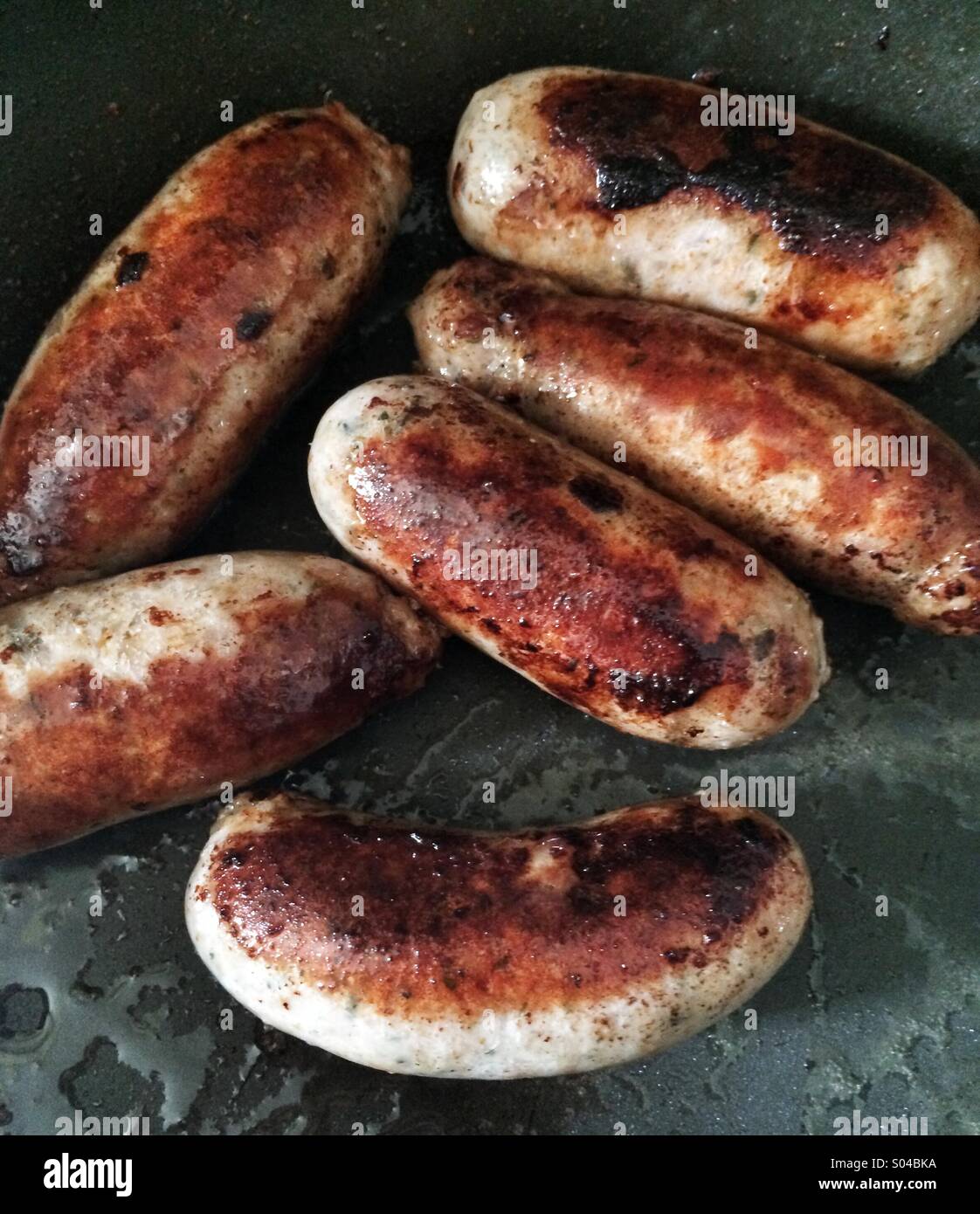 Sausages sizzling in a frying pan Stock Photo Alamy