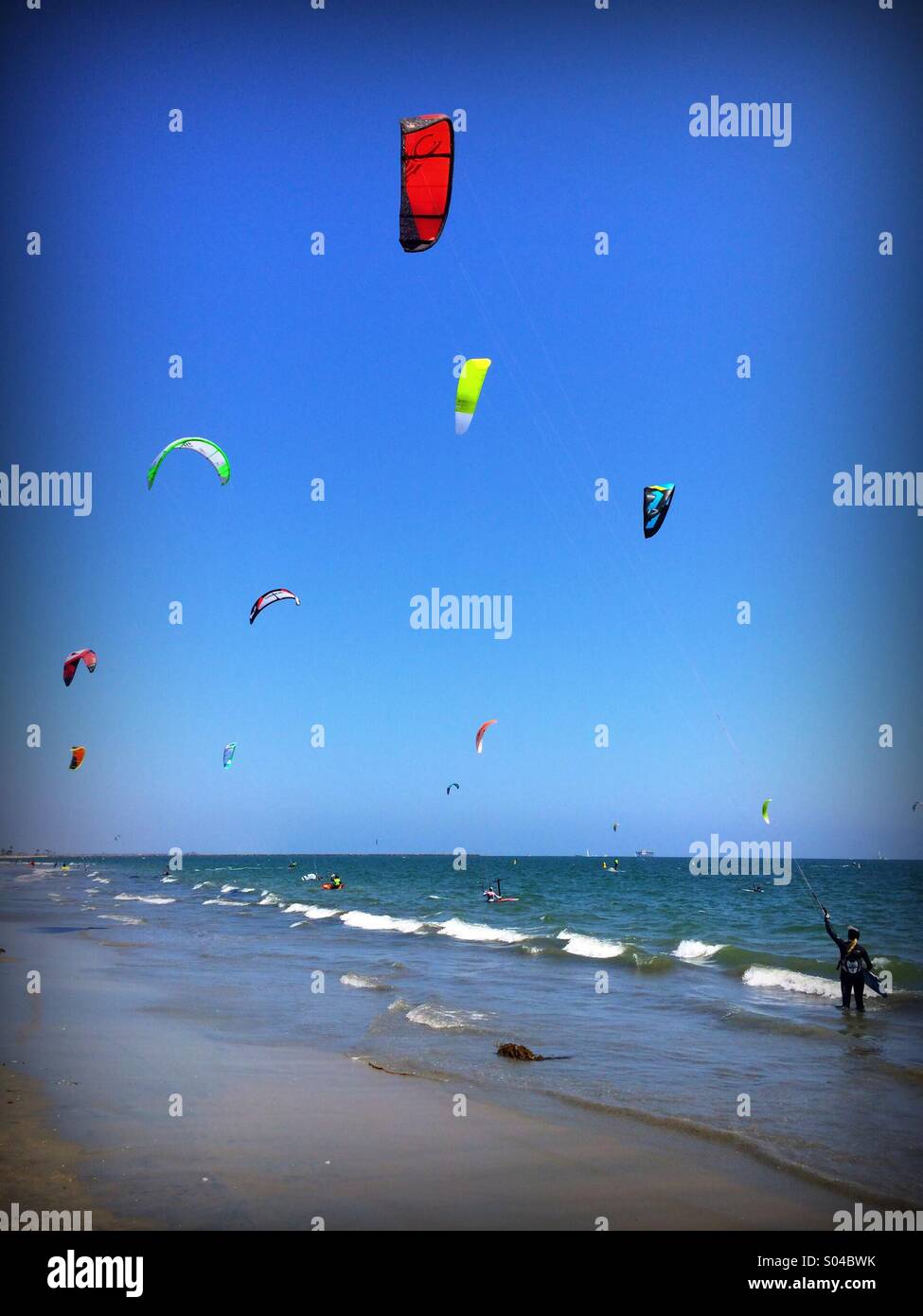 Brightly colored kites controlled by kite surfers at Belmont shores California Stock Photo