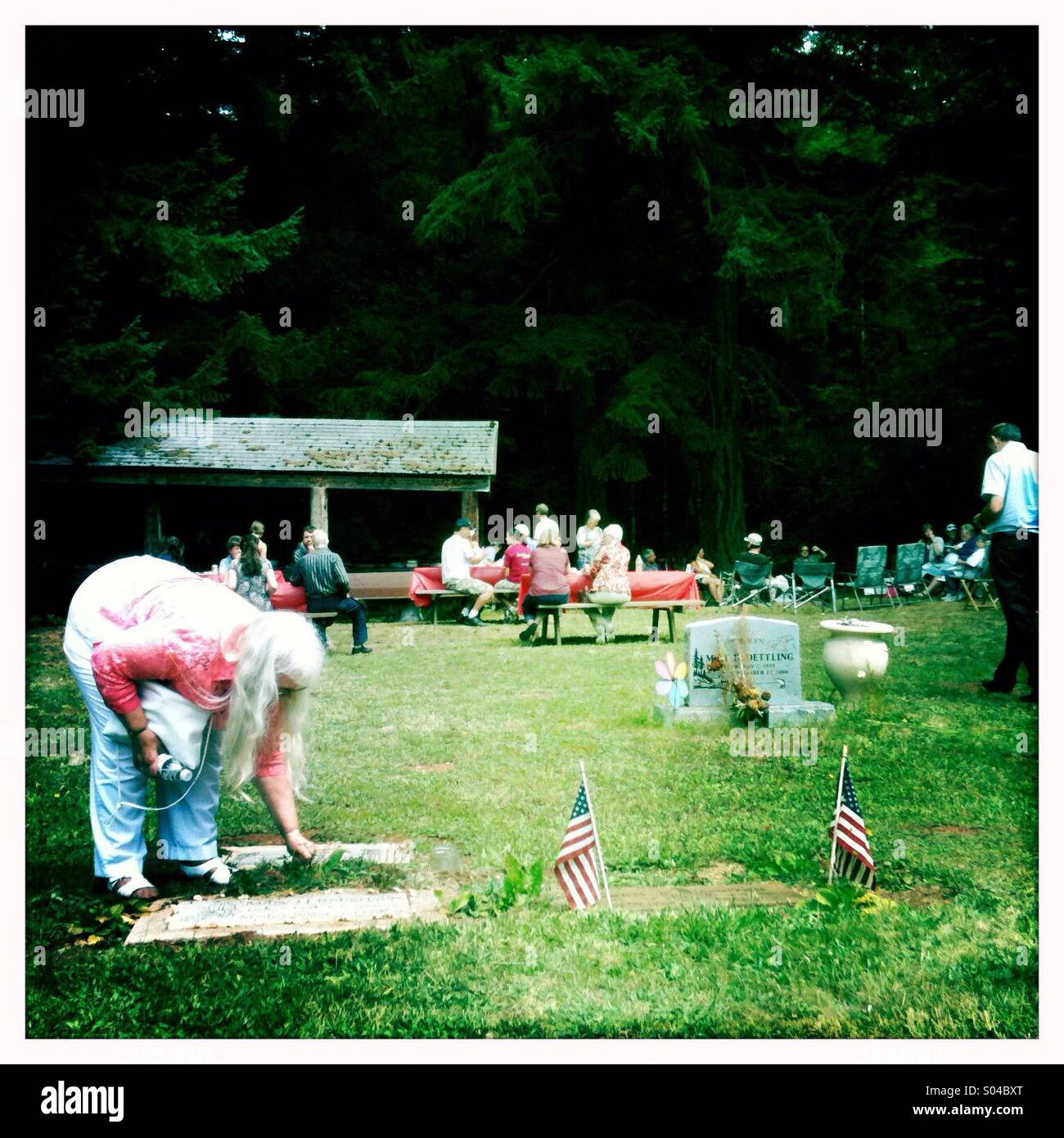 Lady cleaning a headstone at a cemetery Stock Photo Alamy