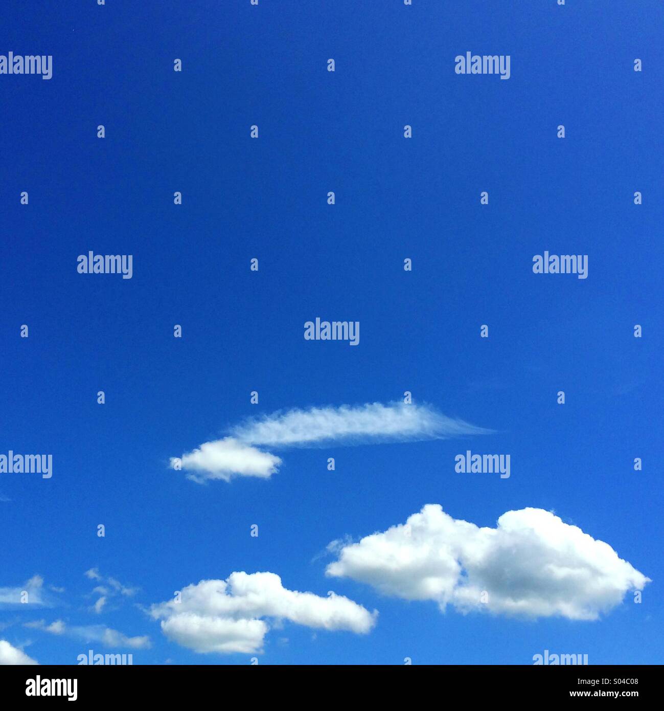 Fluffy clouds against a bright blue sky Stock Photo