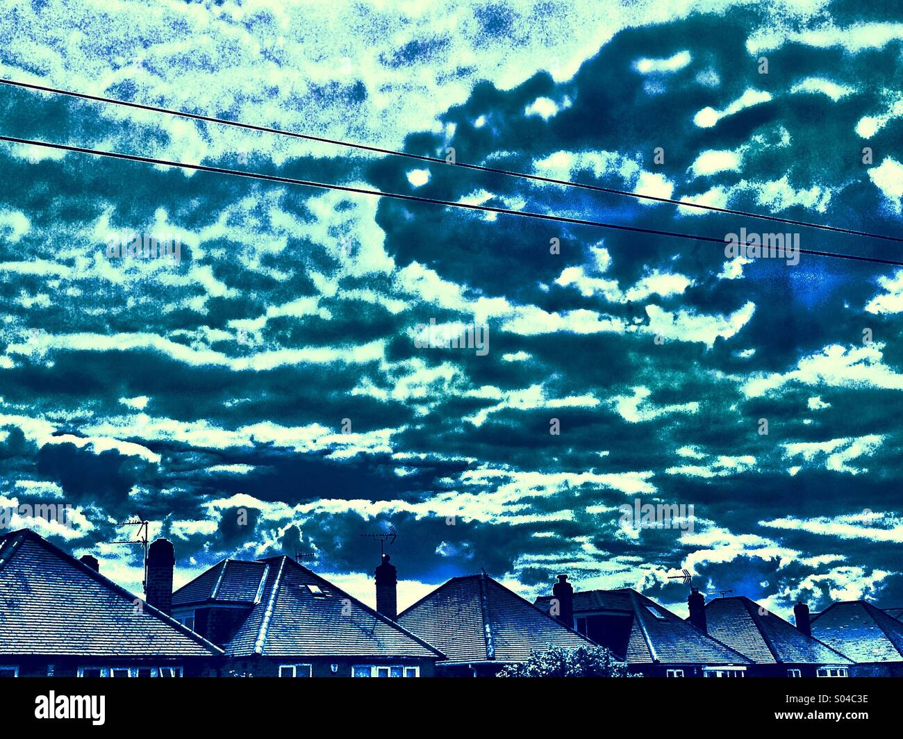 House rooftops telegraph wires and cloudscape - Smartphone Captured Stock Image
