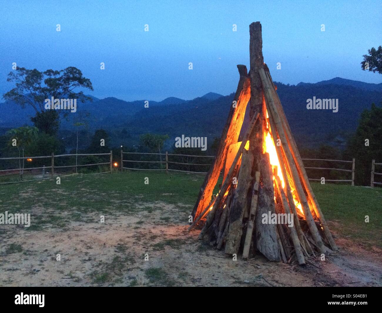 A wood Bonfire starting up in a fenced campsite - Smartphone Captured Stock Image