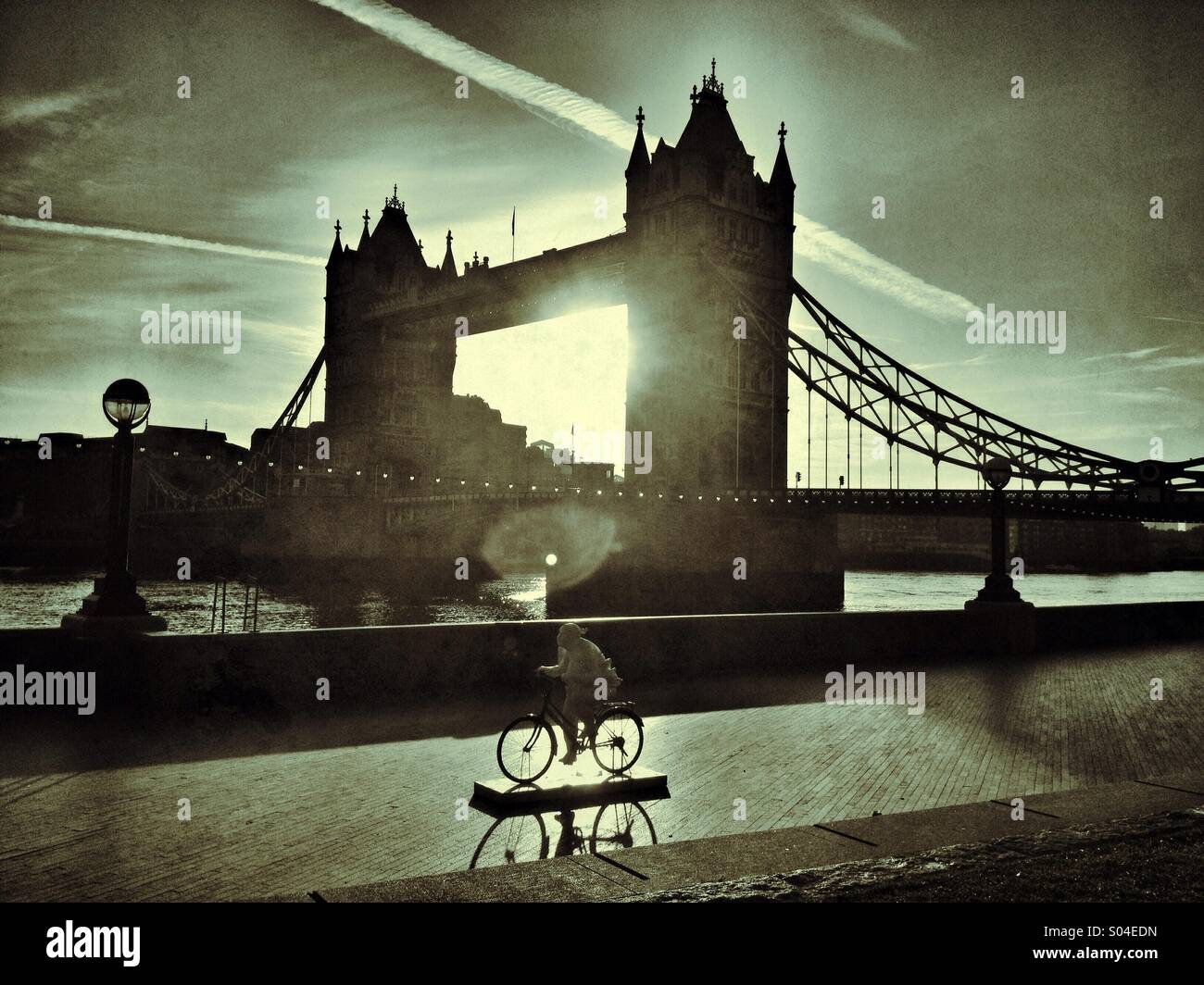 Tower Bridge, London at dawn, with a sculpture of a cyclist in the foreground - Smartphone Captured Stock Image