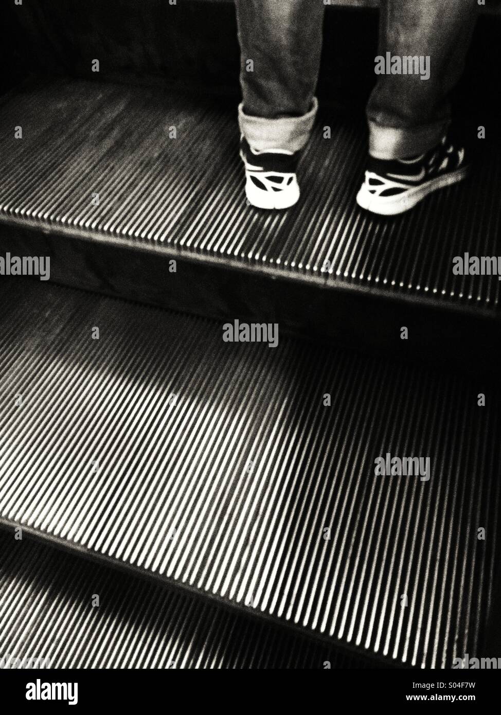 Man standing on escalator Stock Photo - Alamy