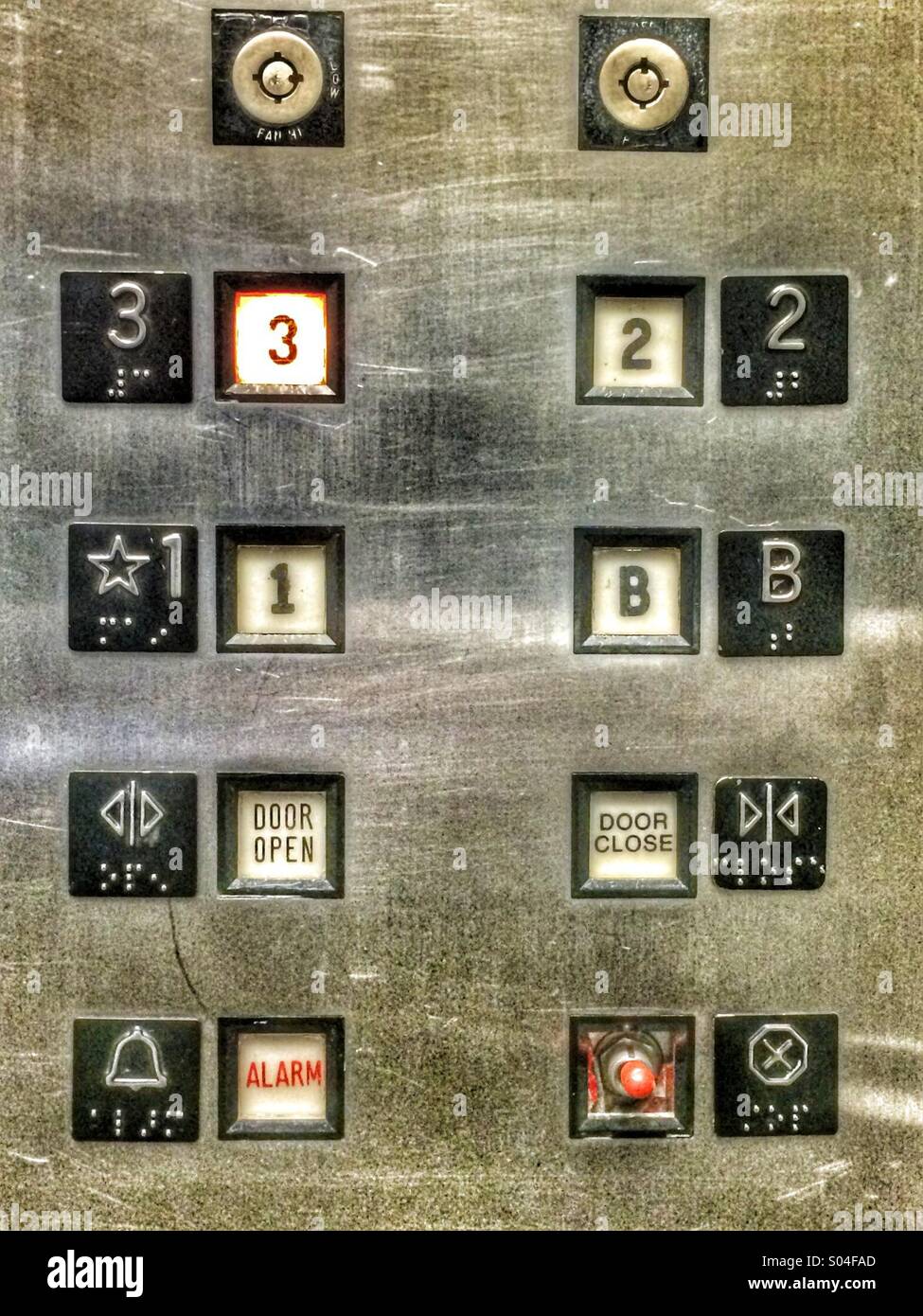 Button plate in an elevator with three floors Stock Photo