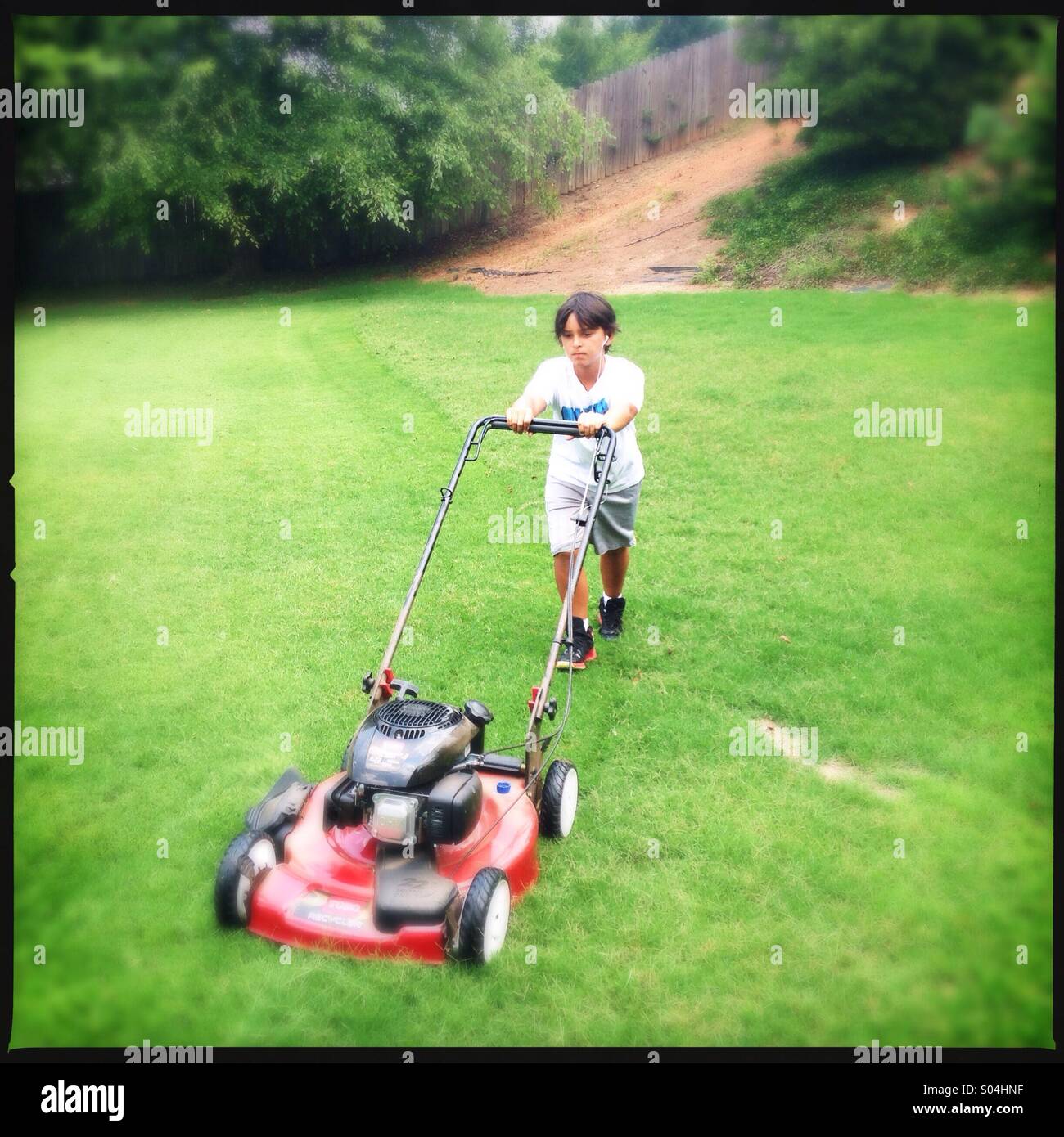 Little boy cutting grass Stock Photo