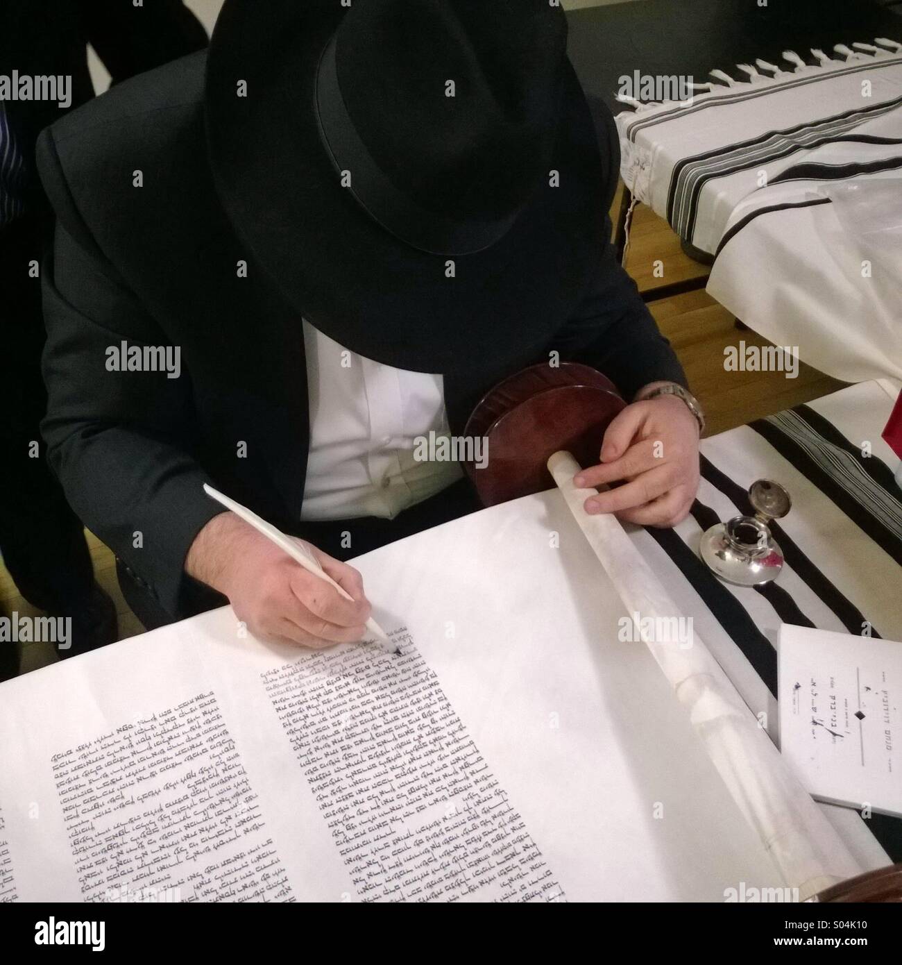 A Rabbi is finishing copying a new Torah, that a family in the upper west side in Manhattan will donate to their community - Smartphone Captured Stock Image