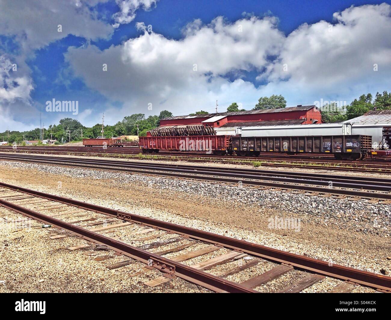 Stationary train cars with empty tracks. Beautiful cloudy sky. Stock Photo