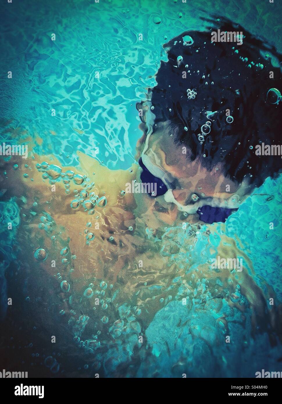 Boy playing under water in a swimming pool Stock Photo
