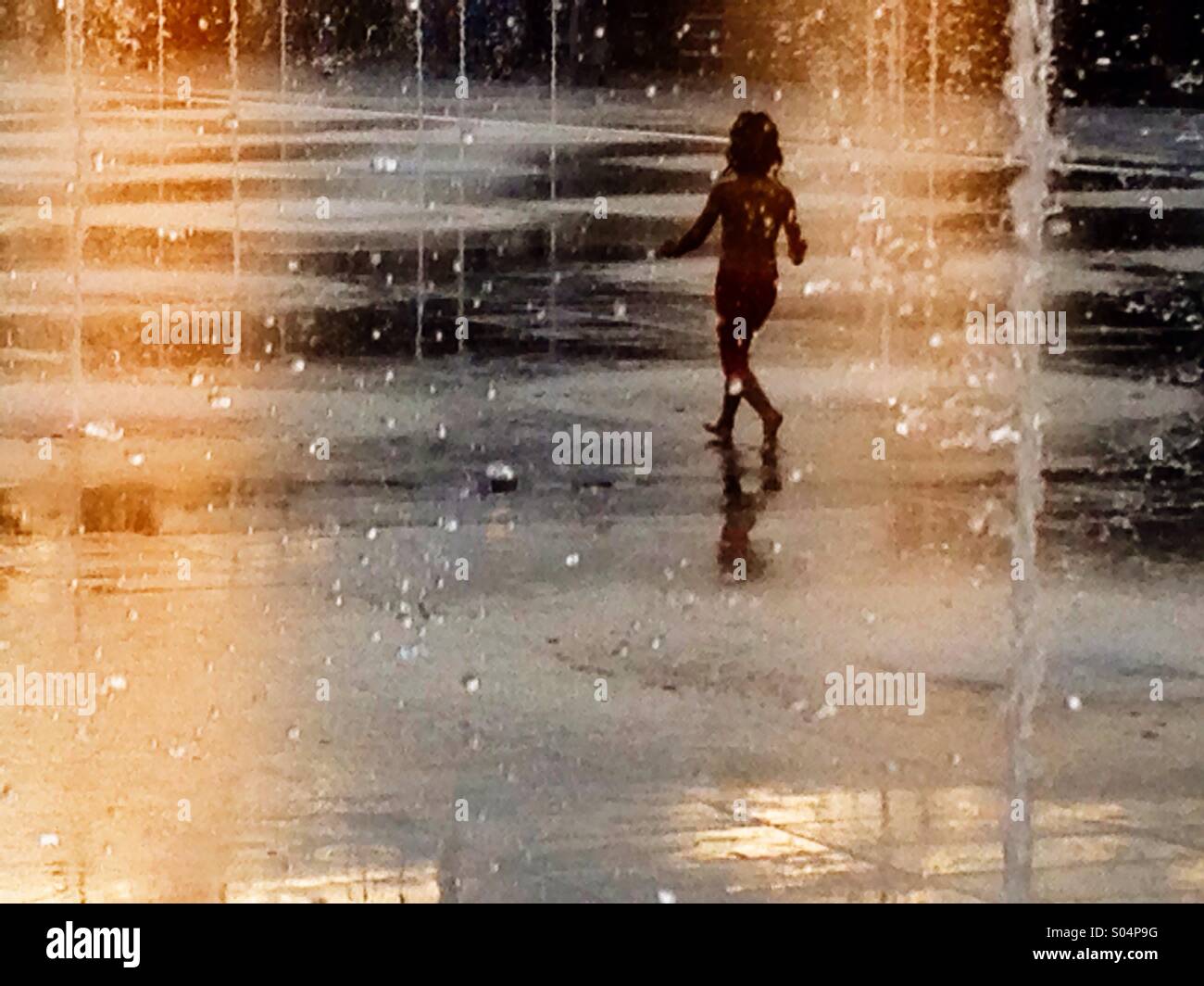 Young girl playing in a fountain Stock Photo - Alamy