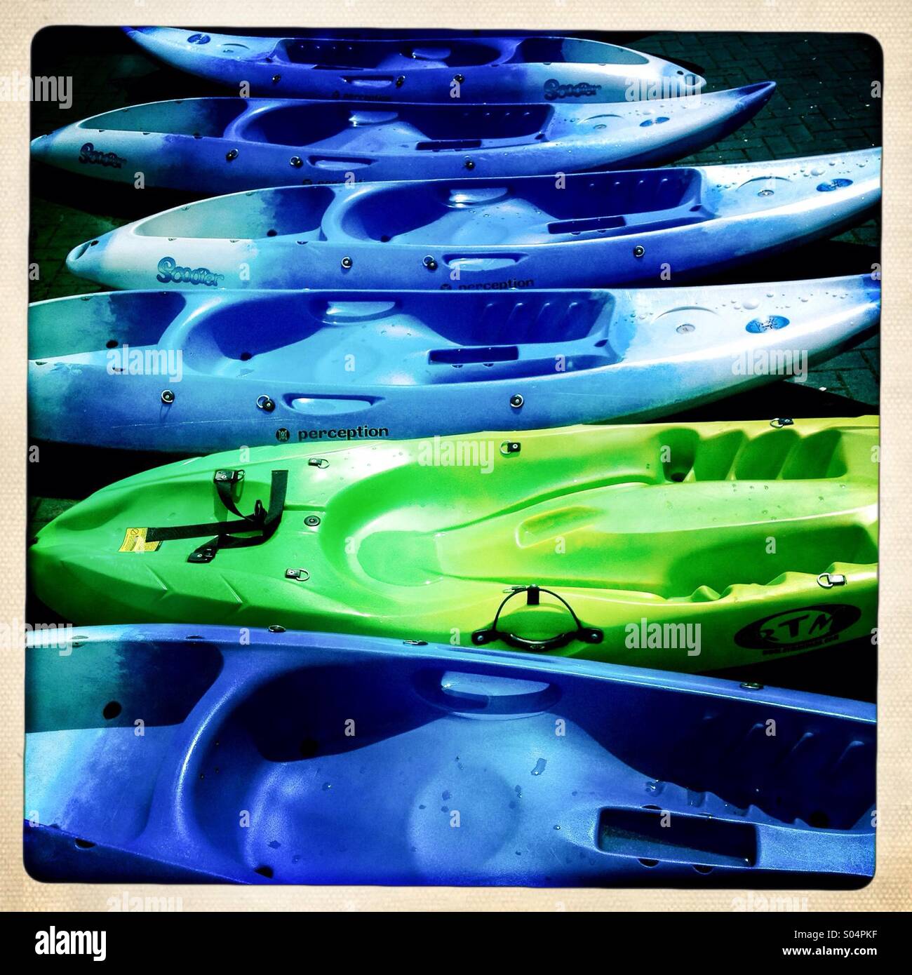 Plastic coloured kayaks in a white framed photo. Hipstamatic, Stock Photo