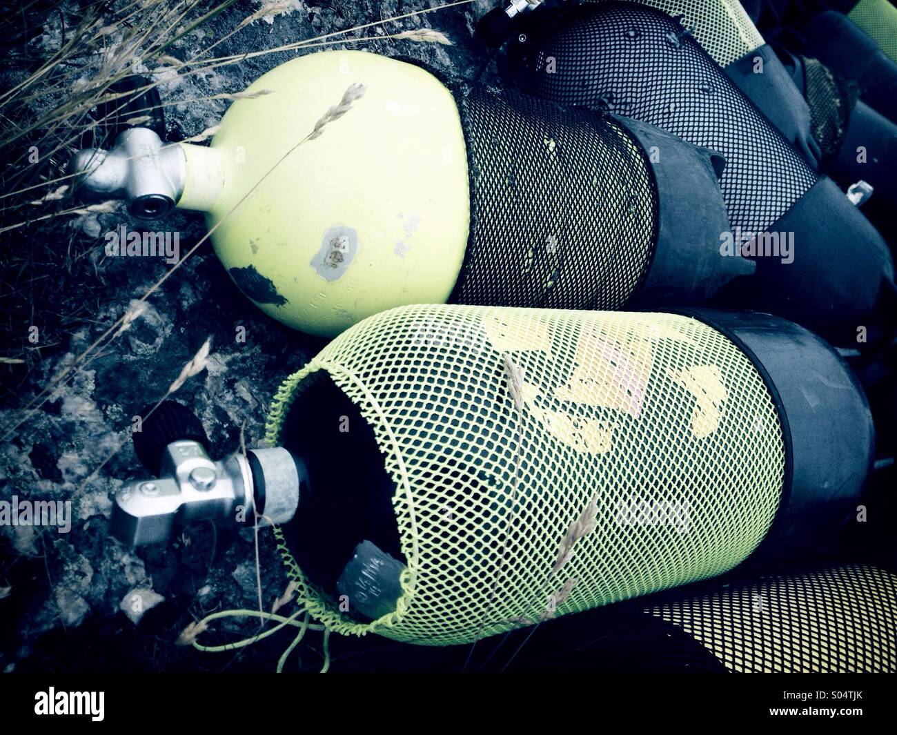 Scuba diving aqualung air tanks lying on rocks. Stock Photo