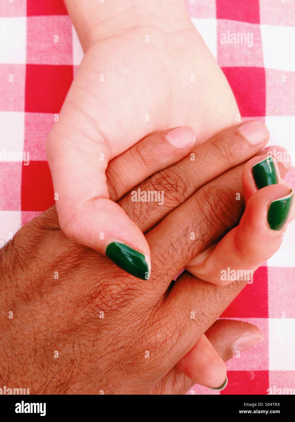 Close-up image of interracial couple holding hands Stock Photo