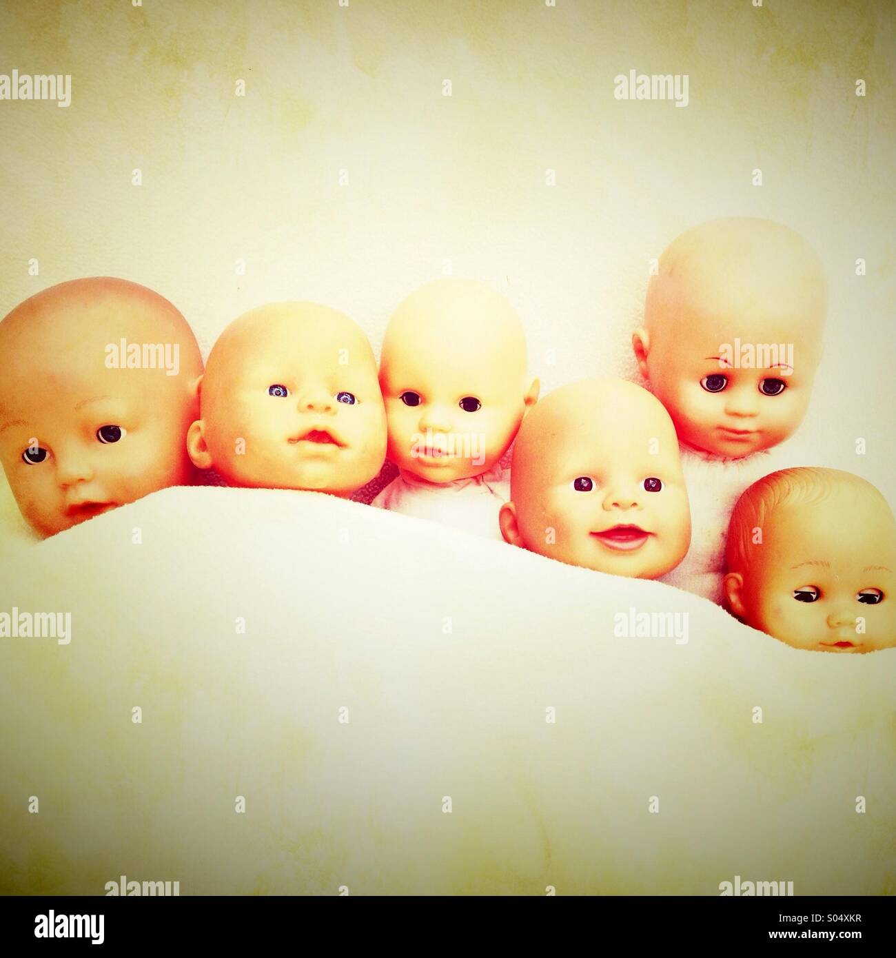 Baby toy dolls tucked up in bed Stock Photo