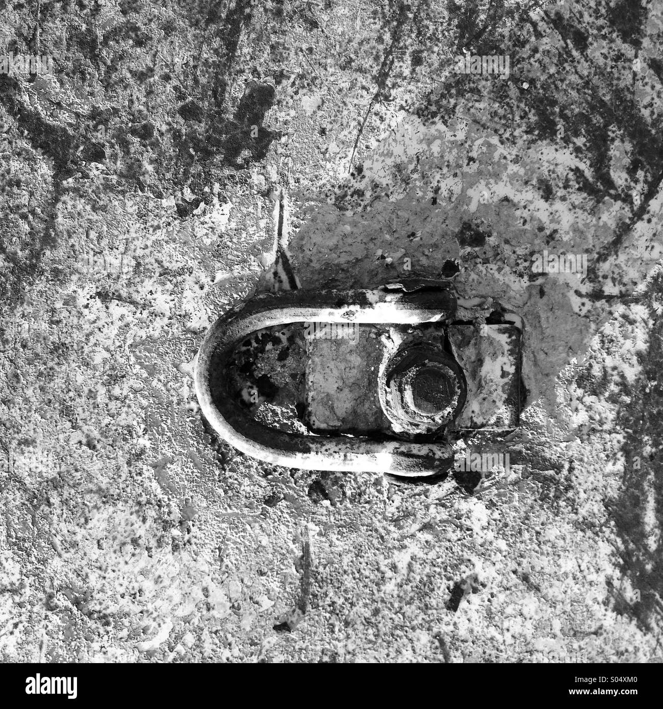 A rusted plate of metal with a bolt and hinged connection. - Smartphone Captured Stock Image