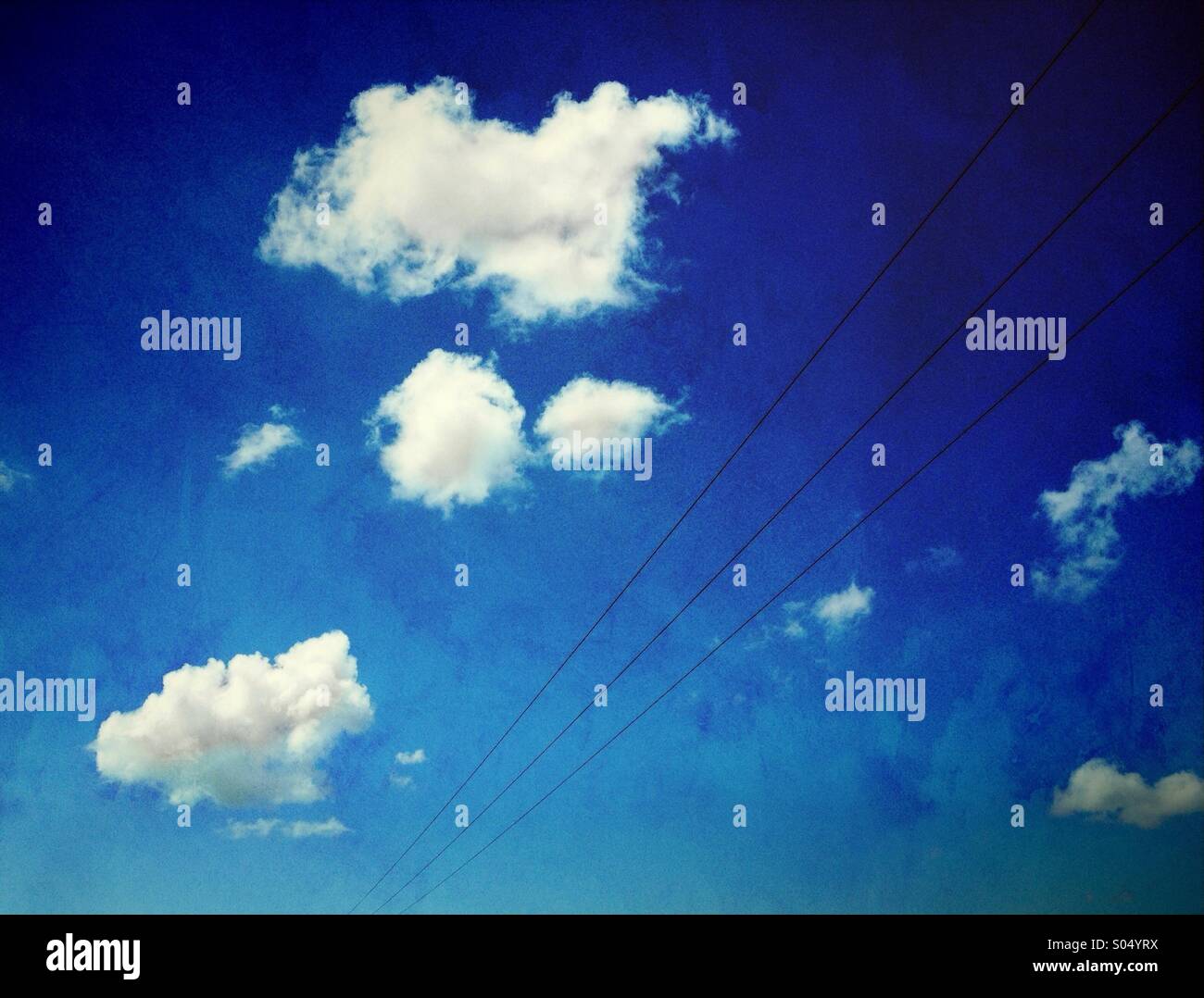 Pylon wires and white clouds against blue sky - Smartphone Captured Stock Image