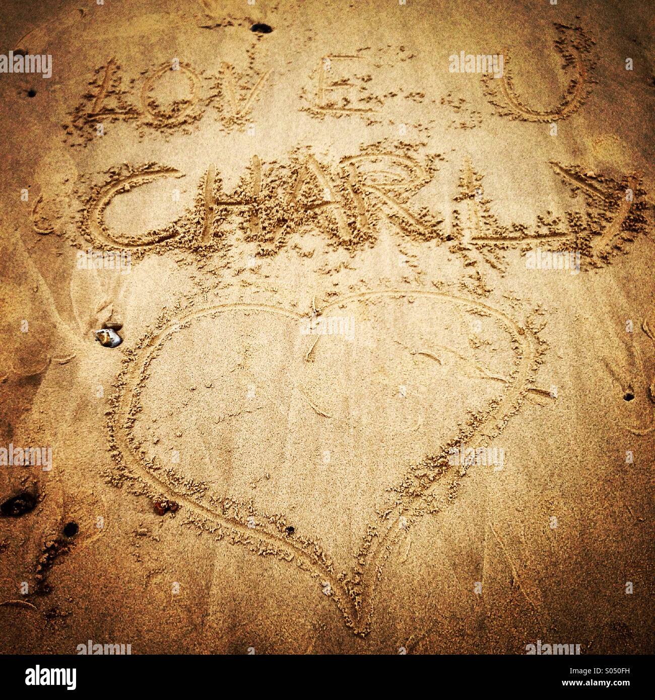 Love u Charly drawn in sand Stock Photo