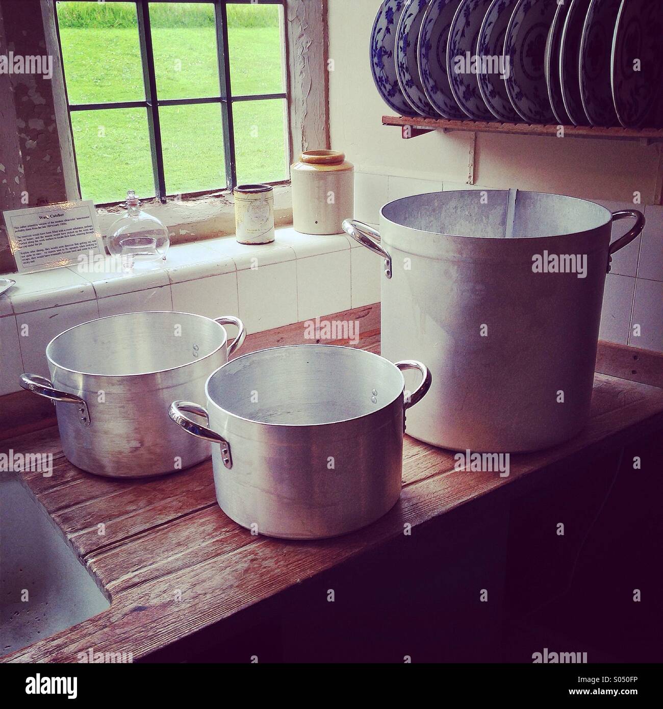 Three pales on a draining board near a window with plates - Smartphone Captured Stock Image