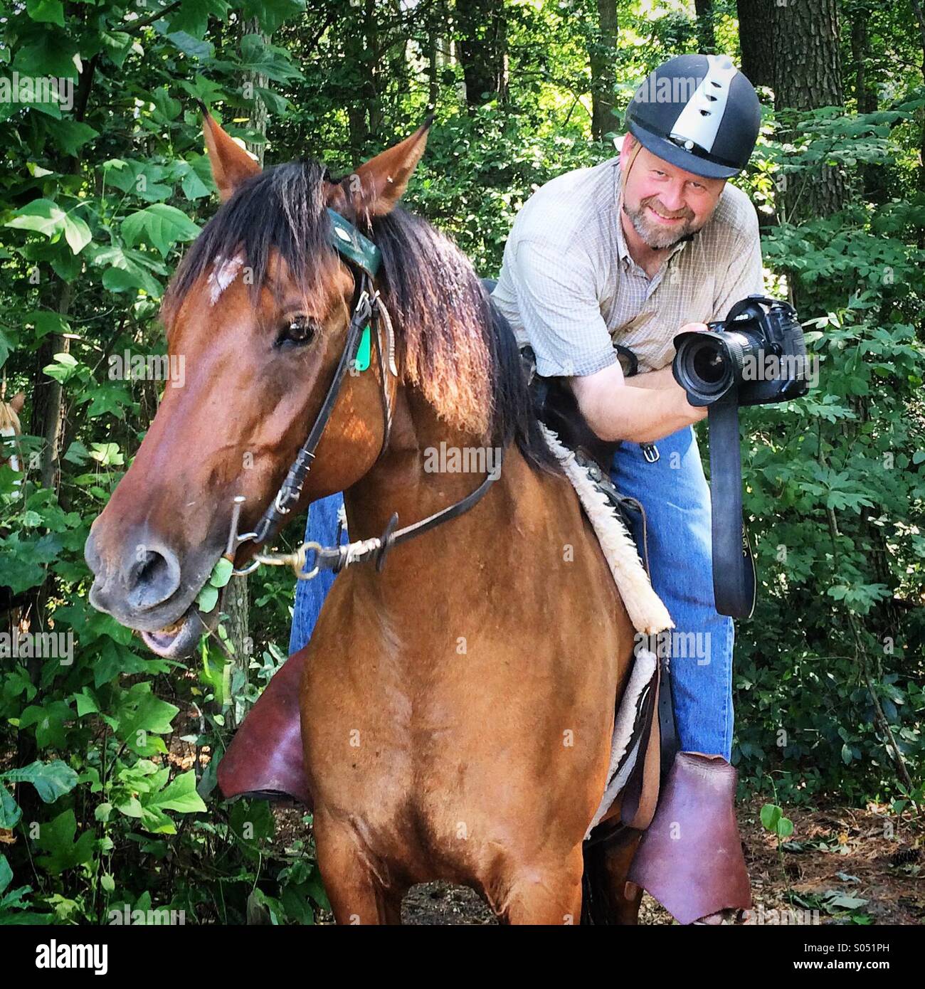 Man taking photographs on horseback Stock Photo