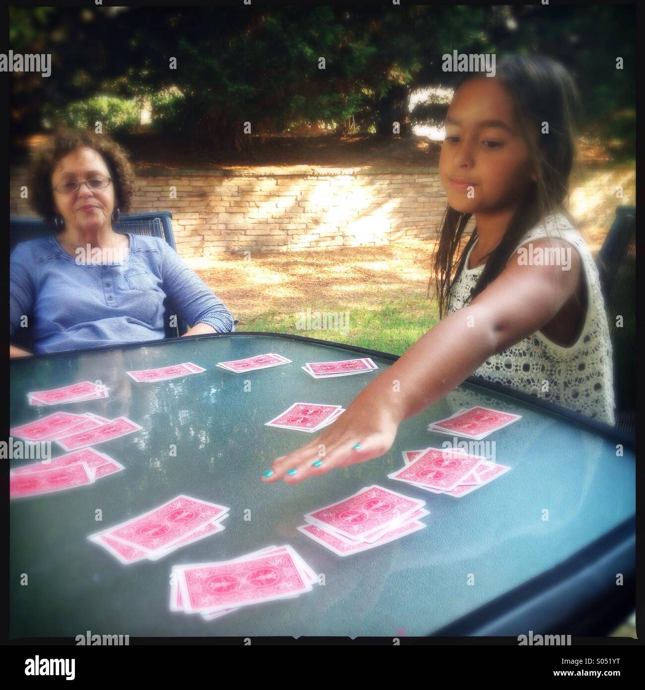 Little girl playing cards with her grandmother Stock Photo