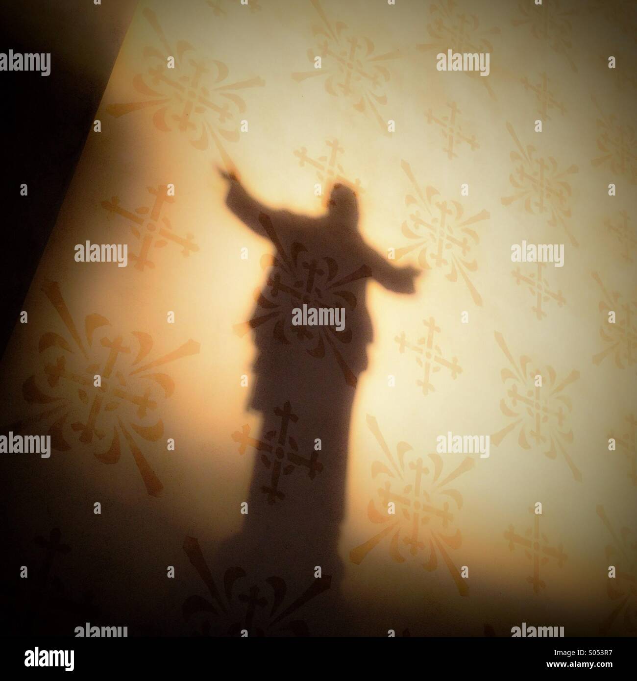 A shadow from a religious statue on a church wall at dawn. - Smartphone Captured Stock Image