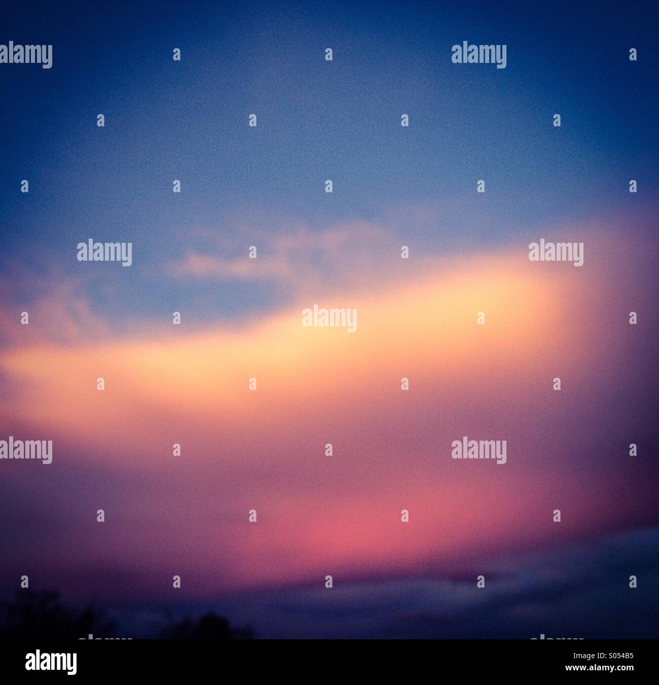 A dreamlike cloud reflects the color of a monsoon sunset, Tucson, Arizona, USA. - Smartphone Captured Stock Image