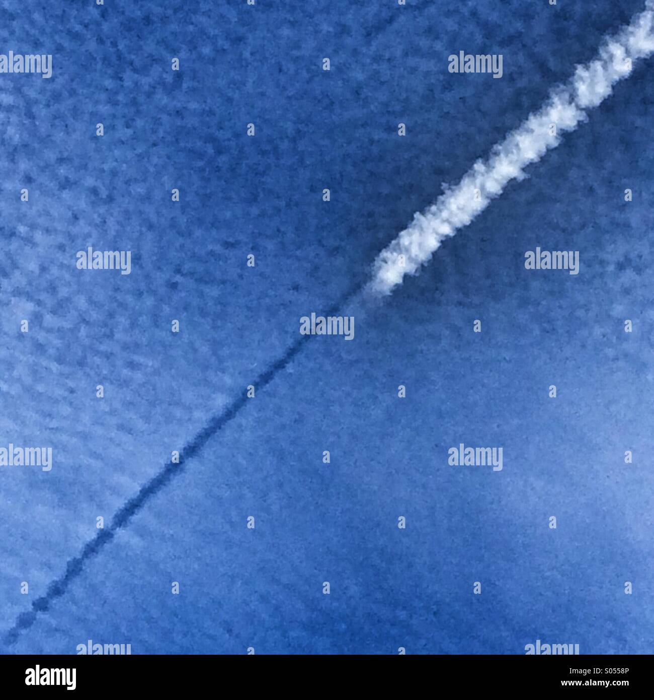 Vapour trail and path of plane in the sky - Smartphone Captured Stock Image