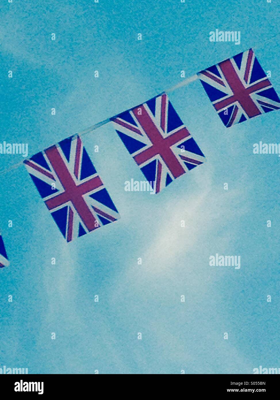 Union Jack flags against a blue sky Stock Photo - Alamy
