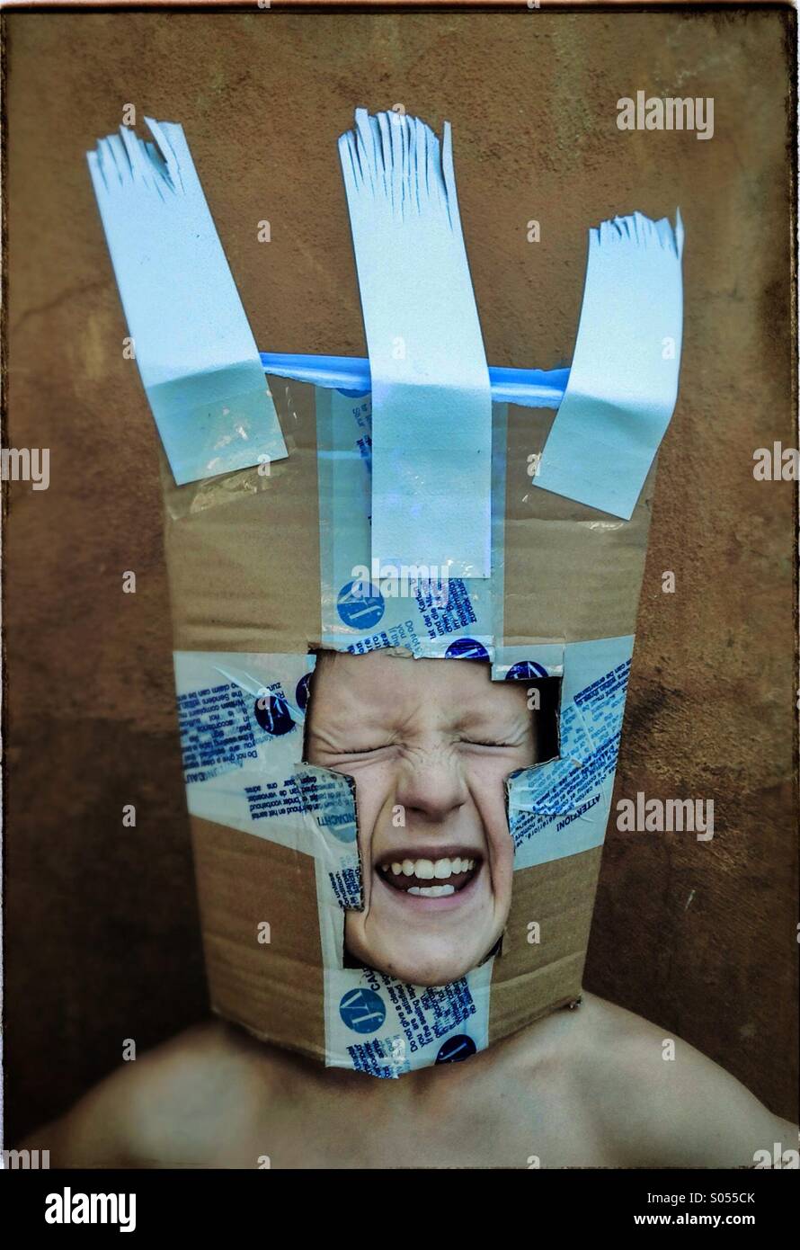 Boy playing with a carton box mask Stock Photo