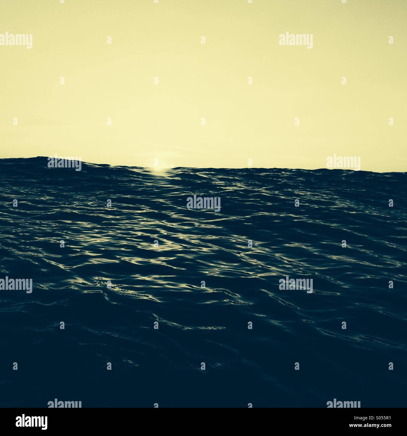 First light in the ocean as the sun appears on the horizon Stock Photo