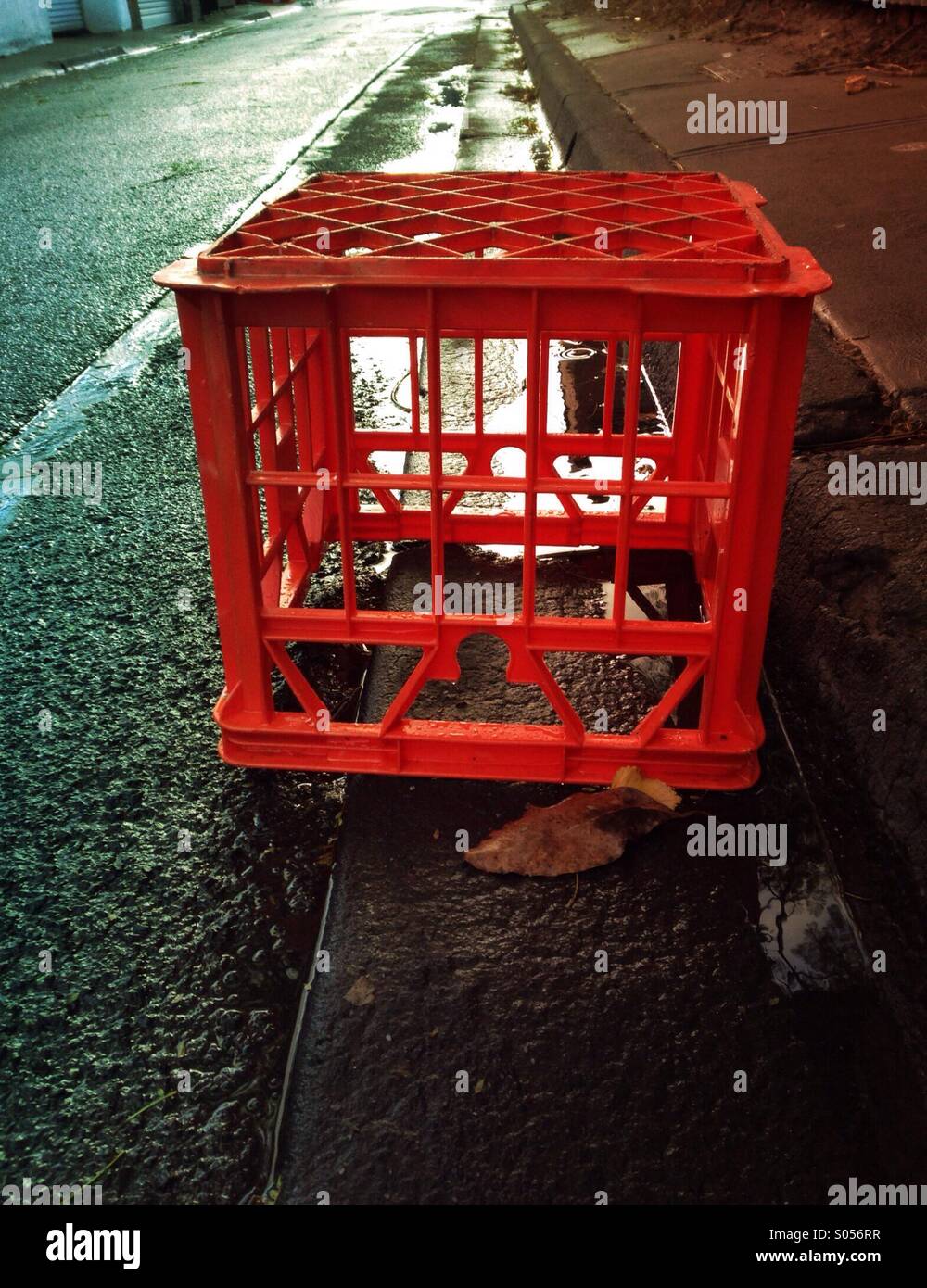Red milk crate in the gutter on the road discarded Stock Photo Alamy