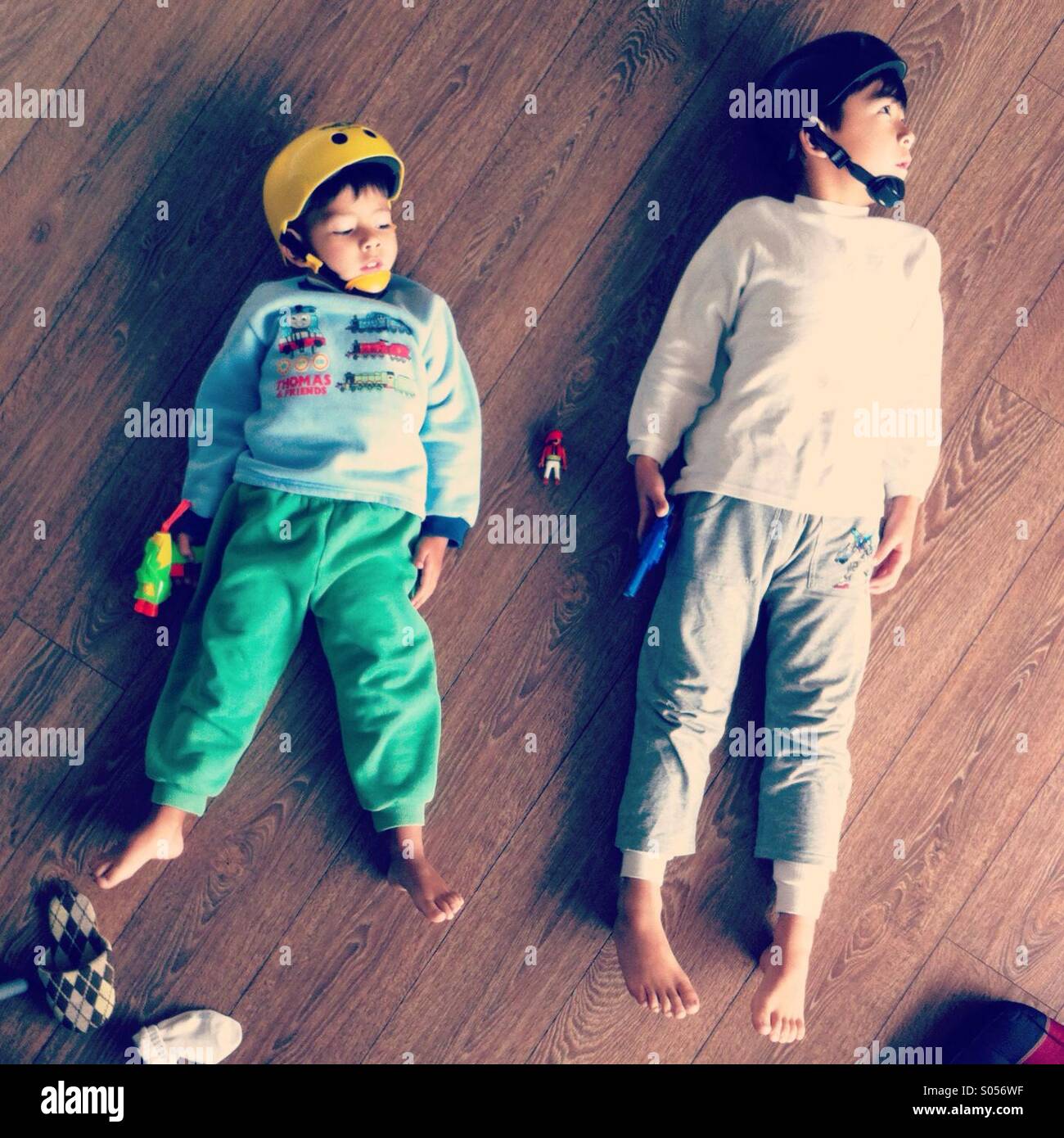 It's a photo of two brother pretenting flying into space. They have helmeys and toys guns - Smartphone Captured Stock Image