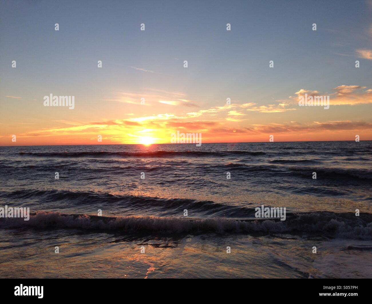 Sun setting over the ocean. Stock Photo