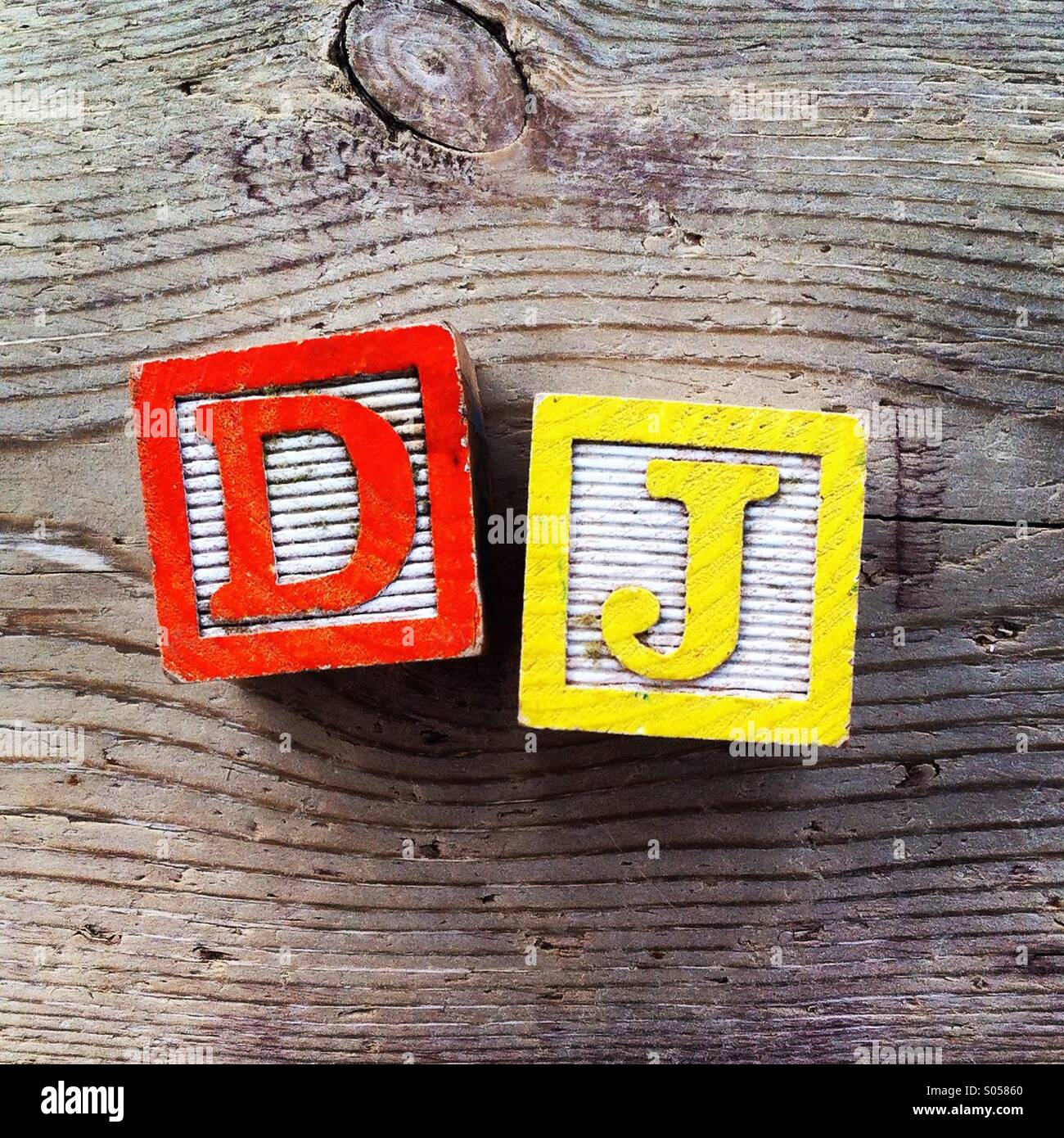 It's a photo of two wood cubes side by side to create the acronym DJ for Disc Jockay - Smartphone Captured Stock Image