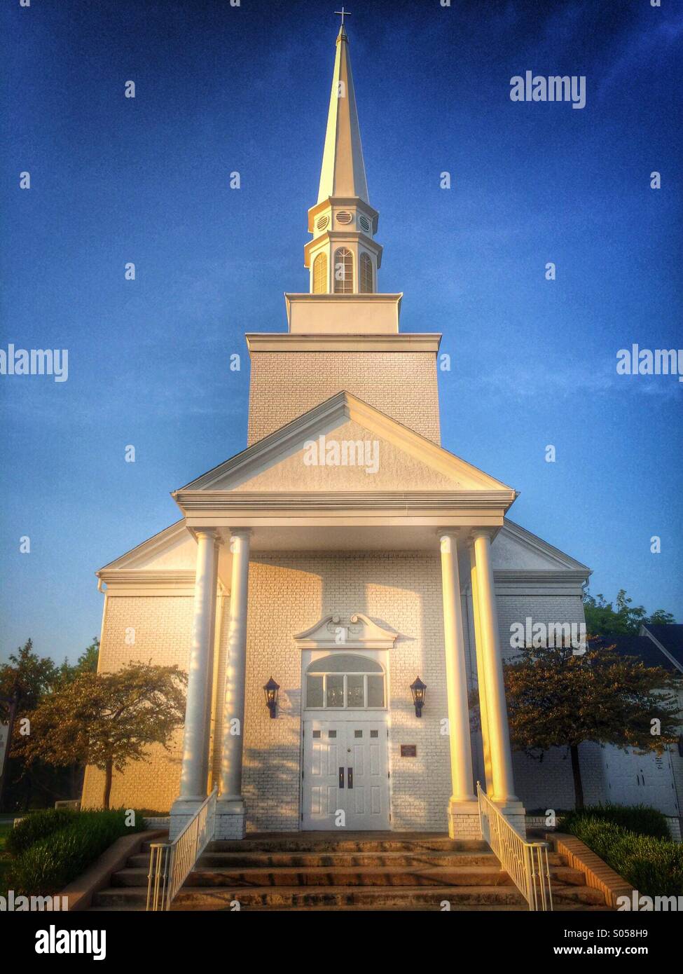 A traditional church and steeple against a deep blue sky - Smartphone Captured Stock Image