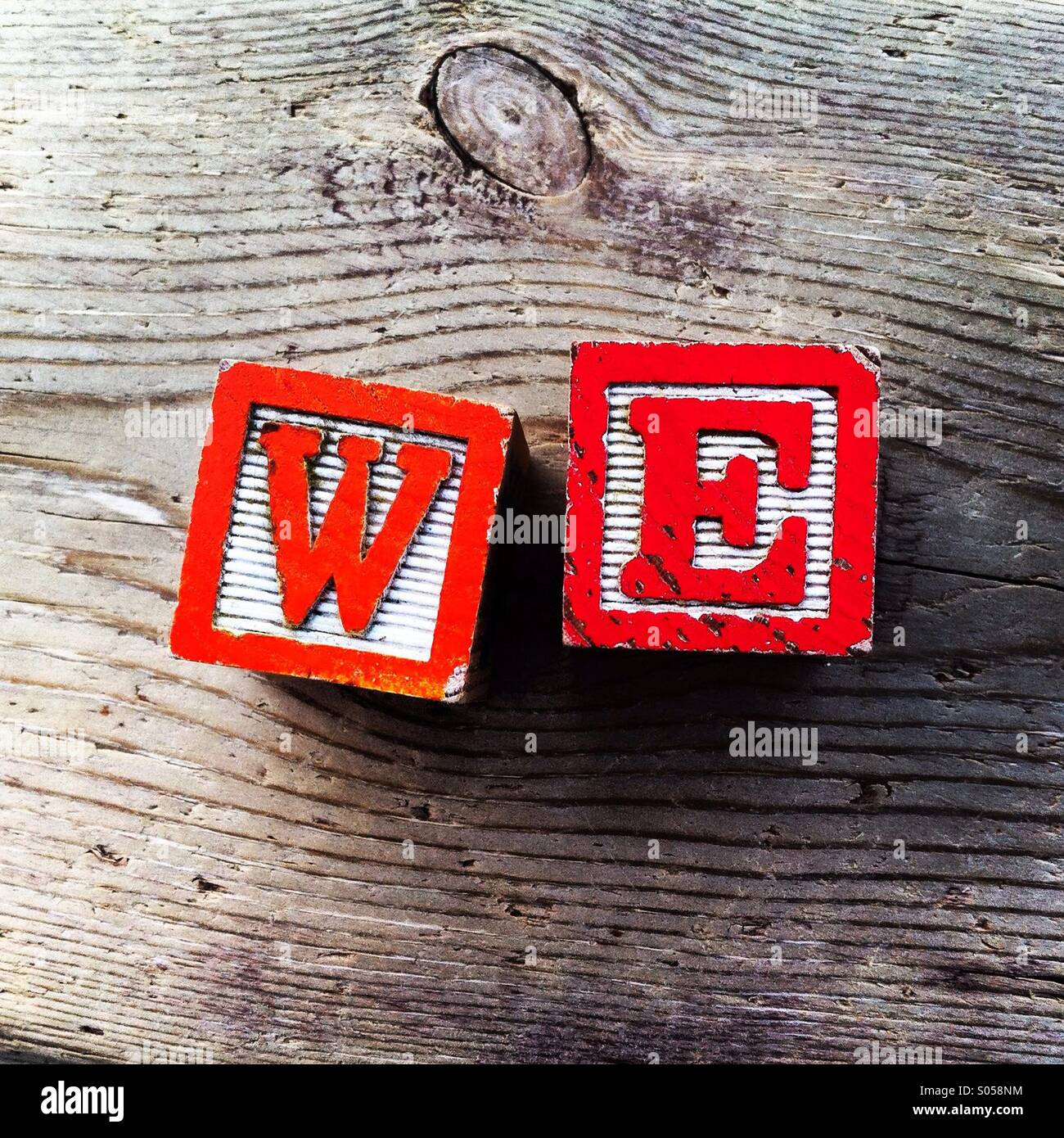 It's a photo of 2 wood cubes toys with letters that create the word WE. - Smartphone Captured Stock Image