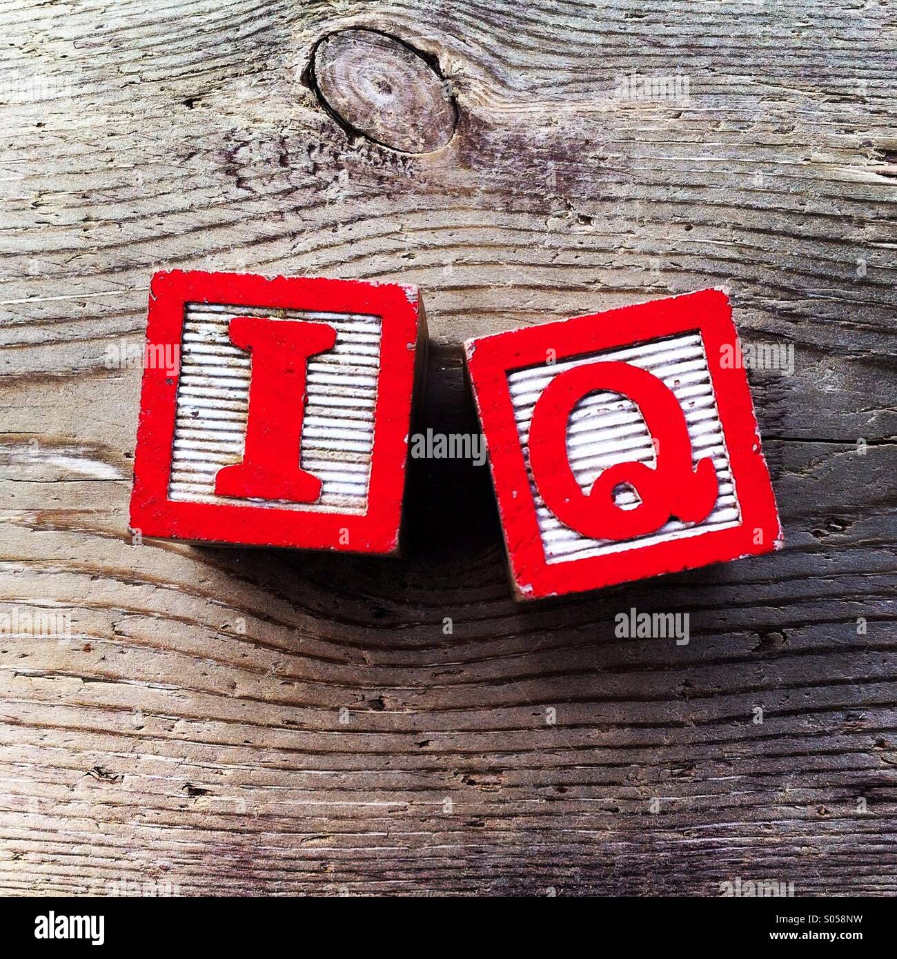 It's a photo of two wood cubes toy with letters that form the word IQ Stock Photo