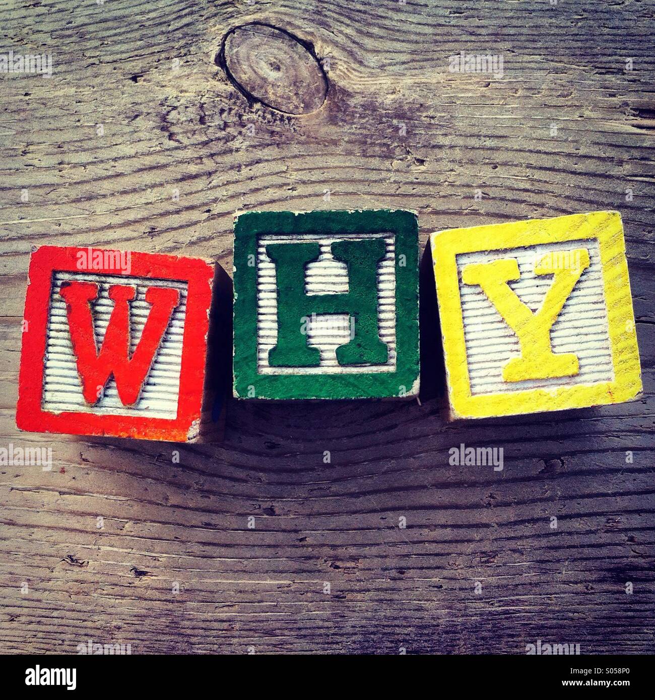 It's a photo of two wood cubes toy with letters that form the word WHY Stock Photo