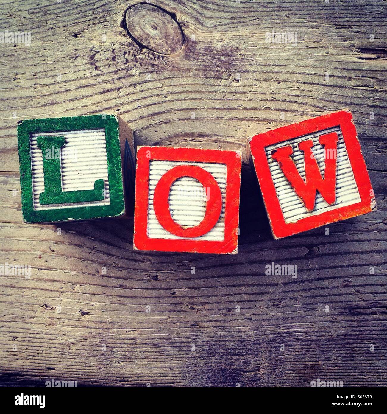 It's a photo of 3 wood cubes toy with letters that form the word LOW - Smartphone Captured Stock Image