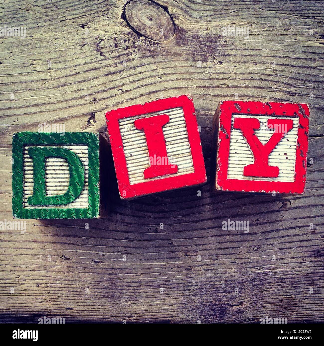 It's a photo of three wood cubes toy with letters that form the acronym DIY for Do it Yourself - Smartphone Captured Stock Image