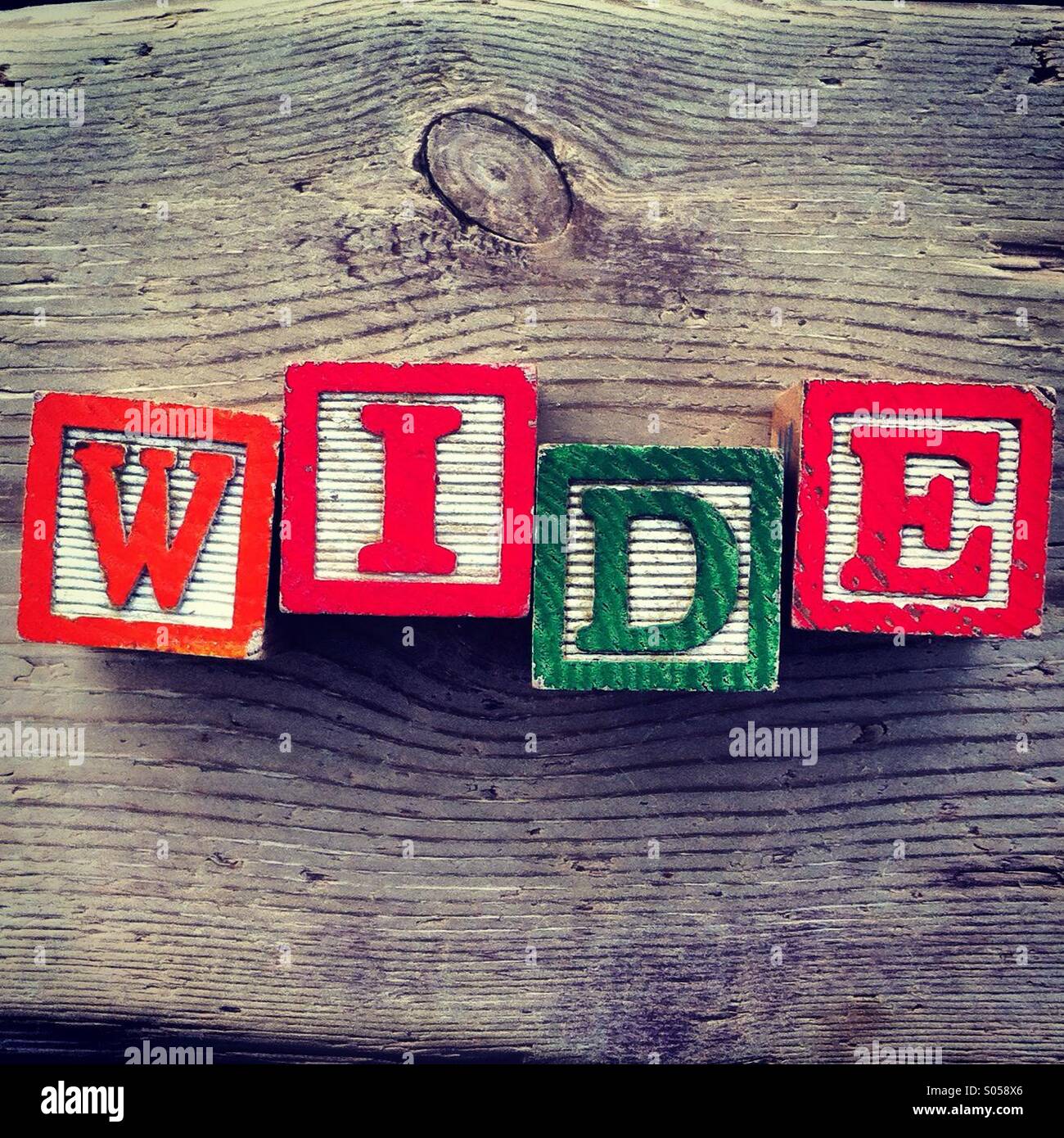 It's a photo of 4 wood cubes toy with letters that form the word WIDE Stock Photo