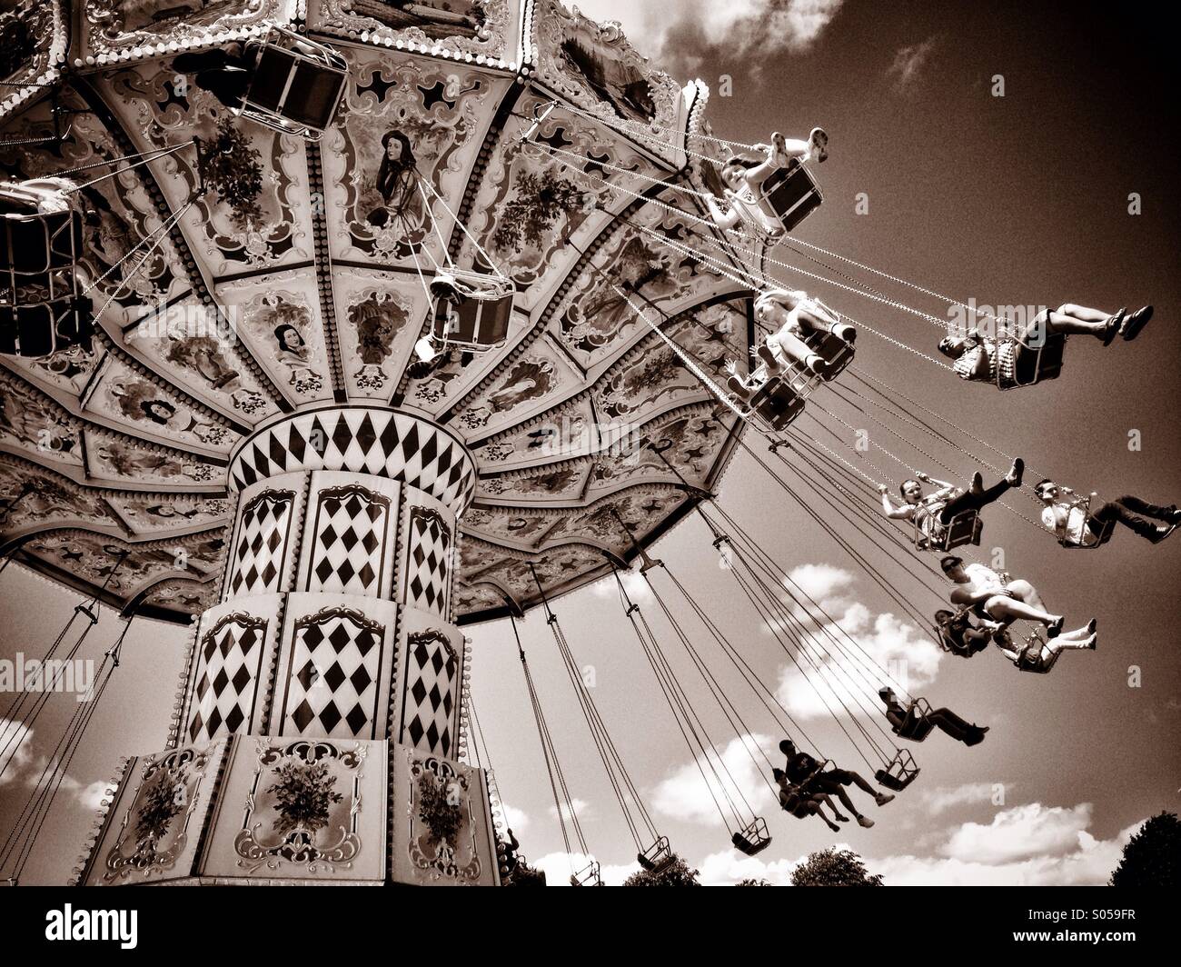 Fun at the Fairground! A Chairoplane or Swing Carousel featuring double seats for Parent with Child use. Photo Credit - © COLIN HOSKINS. - Smartphone Captured Stock Image