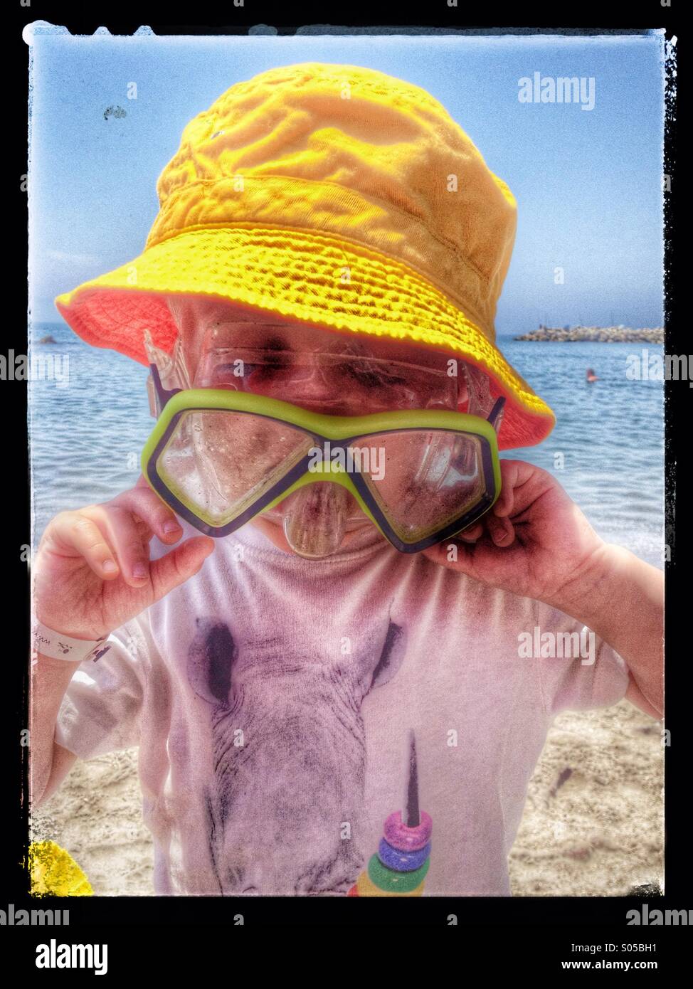 Three year old boy trying goggles which are too big for him Stock Photo