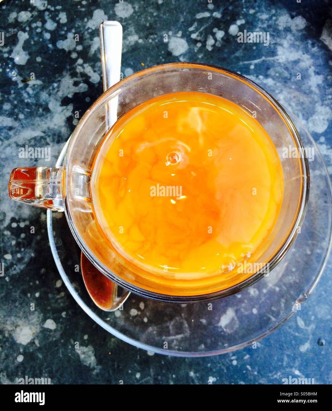 Overhead picture of English breakfast tea with milk just added on a